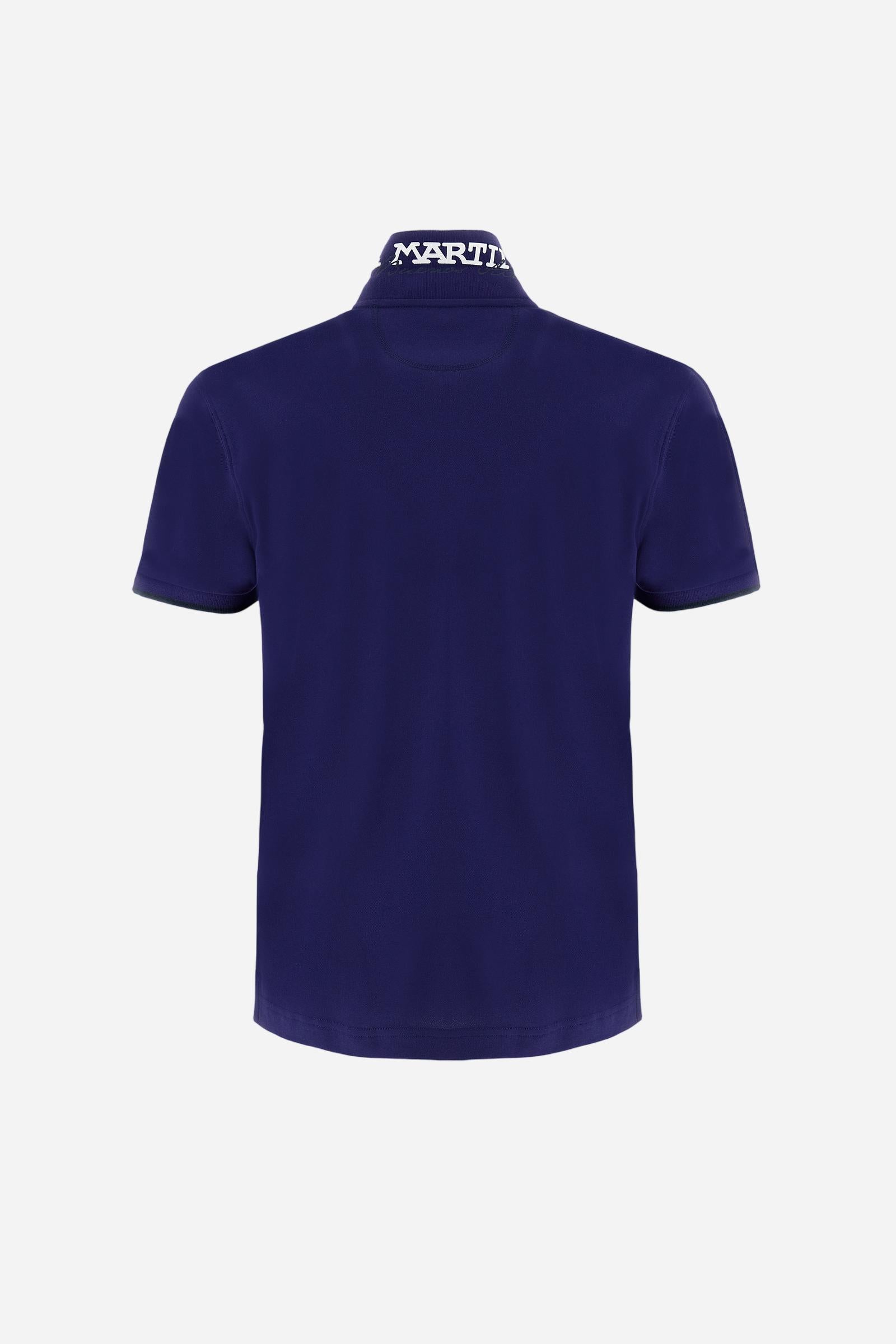 Short-sleeved, single-colour men's polo shirt made of stretch cotton piqué. Fastens with two buttons. The collar and cuffs are ribbed, and there is a colour-contrasting trim at the bottom of the collar. Inside the collar there is a grosgrain ribbon of a different shade. The logo is embroidered on the chest in a contrasting colour. The fit is slim. The model is wearing a size L. - Deep Cobalt