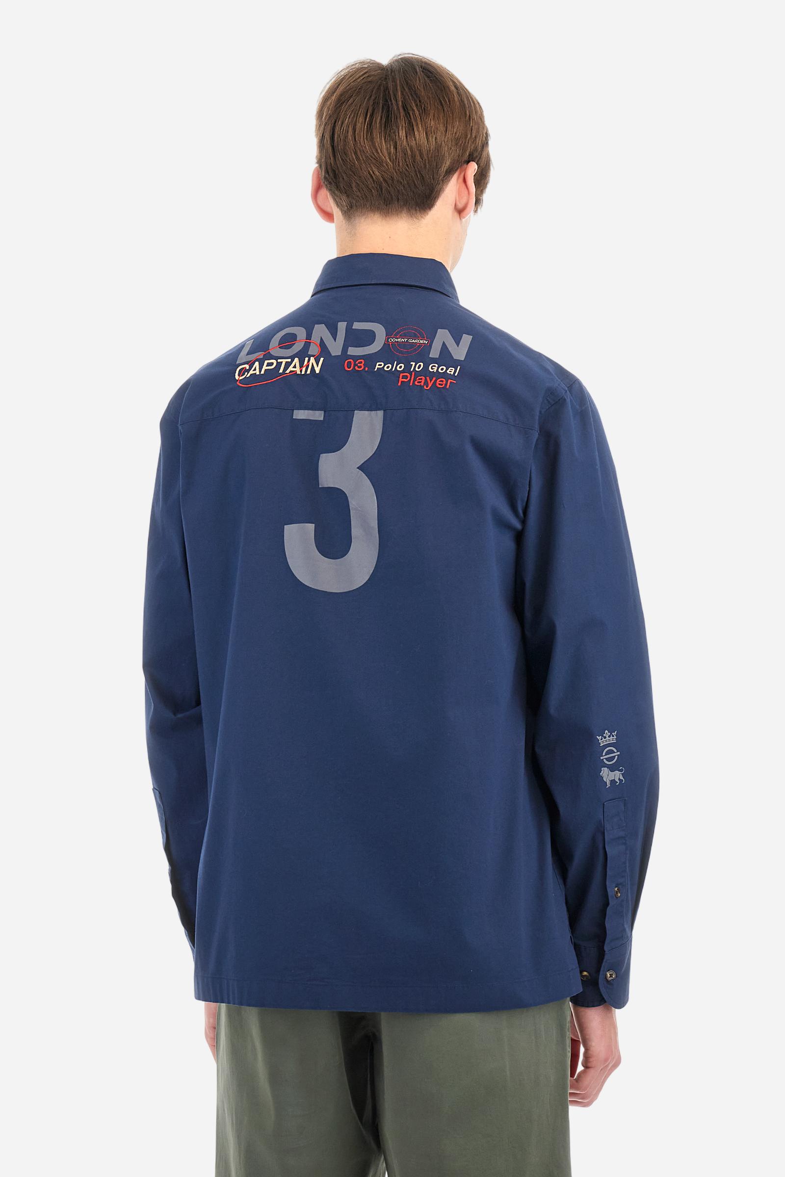 Men's single-colour long-sleeved shirt, made from 100% cotton poplin. Spread collar. Contrasting printed fabric details on the inside of the collar and opening. The numbers on the chest and back graphics are rubberised prints, while the rest of the graphics are embroidered. The logo and La Martina lettering is embroidered on the left chest. The fit is regular. The model is wearing a size L. - Navy