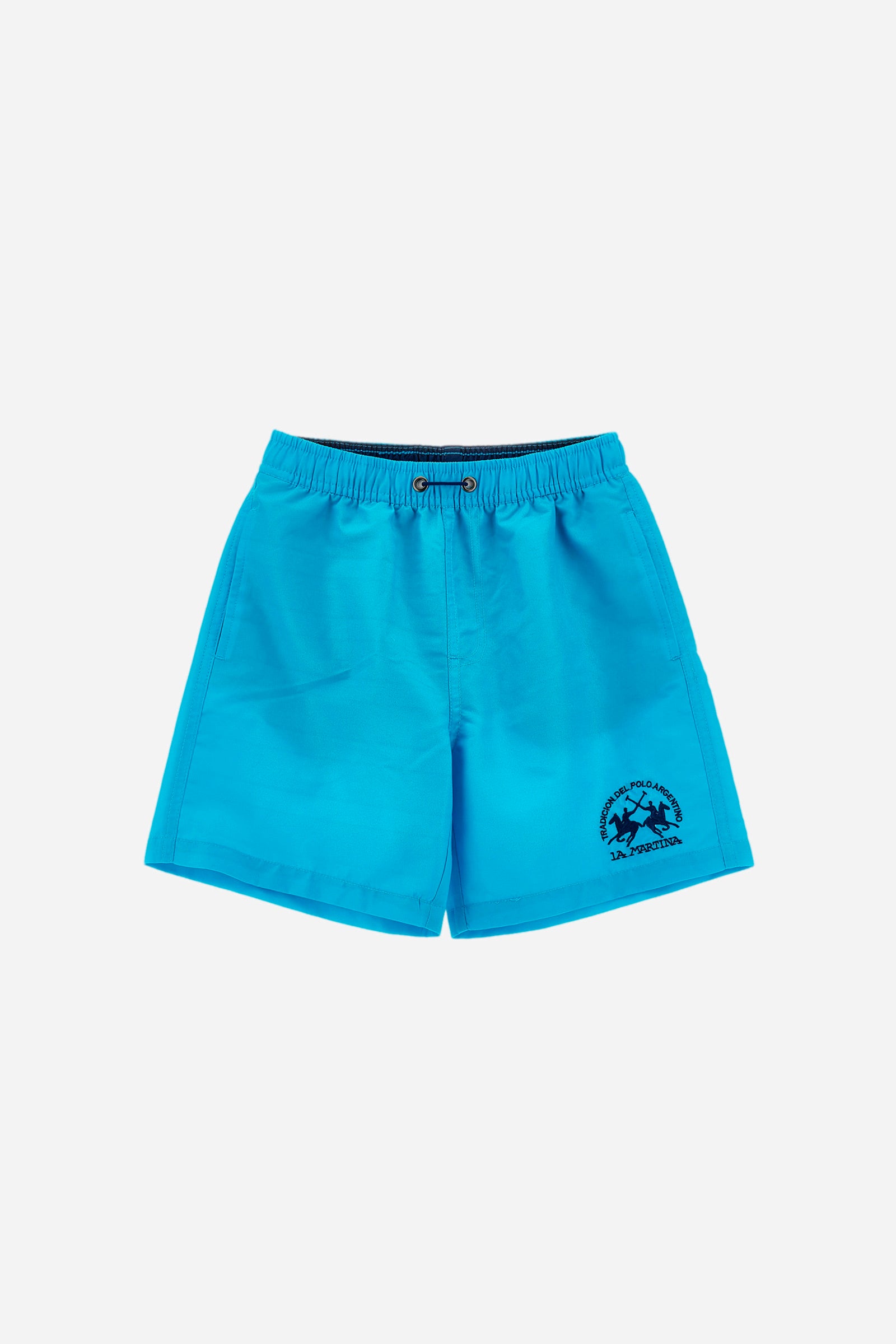 Single-colour boys' costume made of synthetic fabric. Elasticated waist with fake drawstring. There are two slanted pockets on the front. An additional contrasting pocket is applied on the back. The logo is embroidered on the front. - Blue Atoll