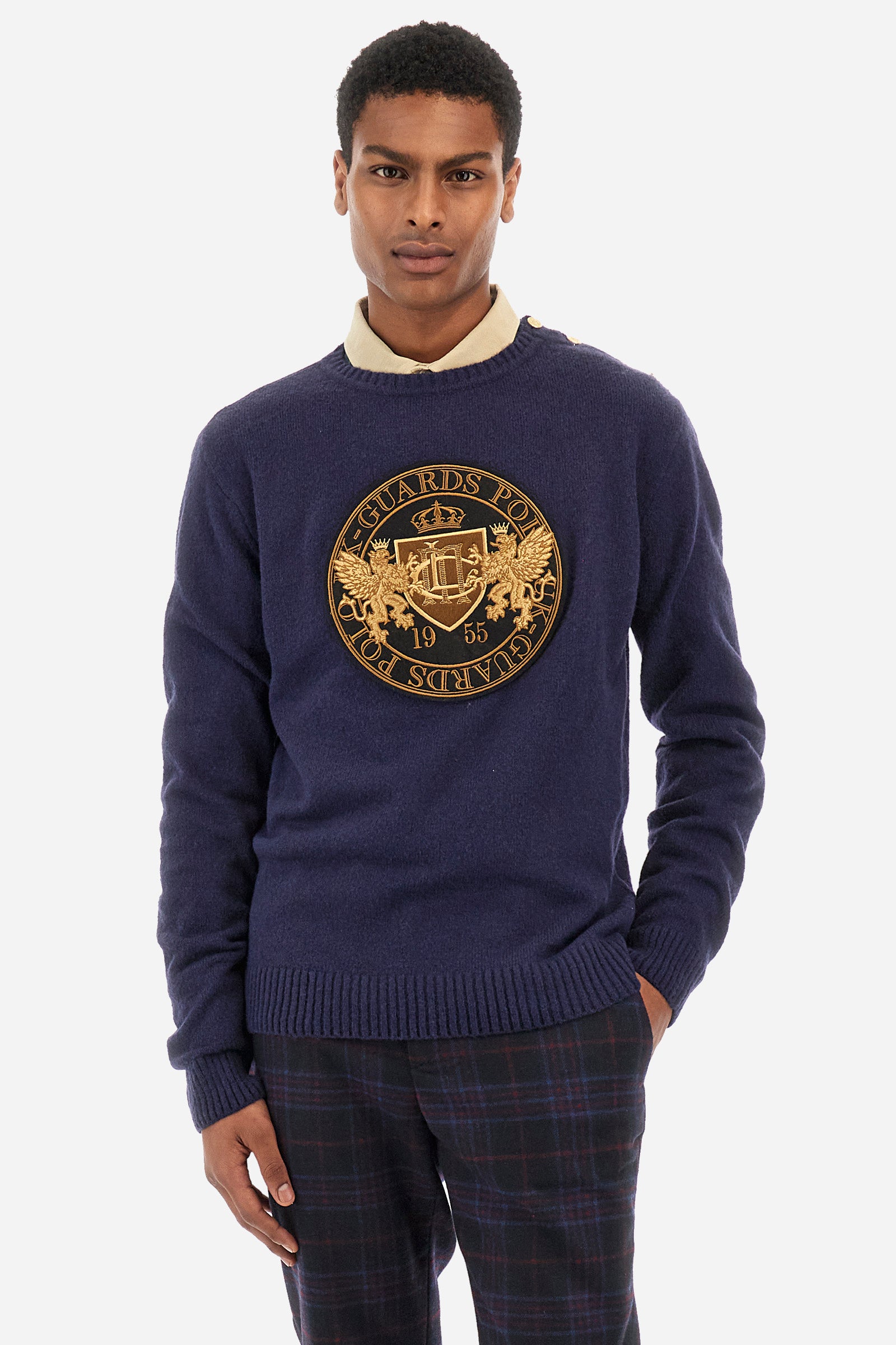 Men’s sweater with long sleeves with crew neck, solid color regular fit. Made of merino wool, it features a large gold embroidery on the front that recalls the Guards capsule. Golden buttons applied on one shoulder and the drawstring at the waist make the garment elegant and perfect for formal outfits or to give a more refined touch. The model is 187 cm tall and wears a size L. - Navy