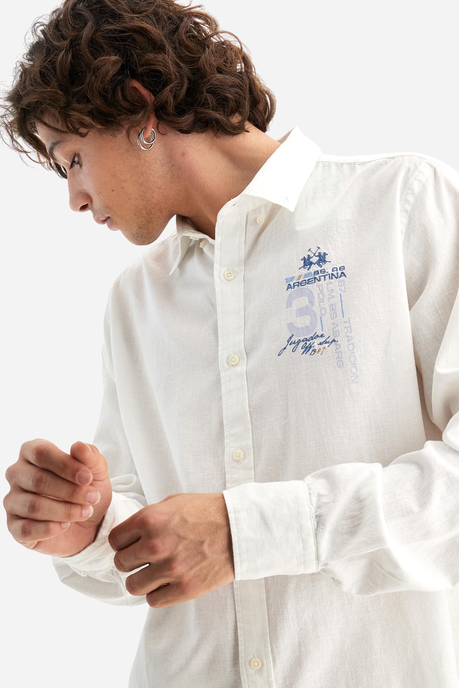 Men's plain long-sleeved shirt made from cotton and linen canvas. Featuring a button-down collar and sleeve openings embellished with contrasting fabric details. The graphic on the chest, over the heart, is created using a combination of embroidery and printing techniques to add a distinctive touch. On the side, at the front, there is a ribbon embroidered with the word Argentina, topped with a print. Regular fit. The model is wearing a size L. - Optic White