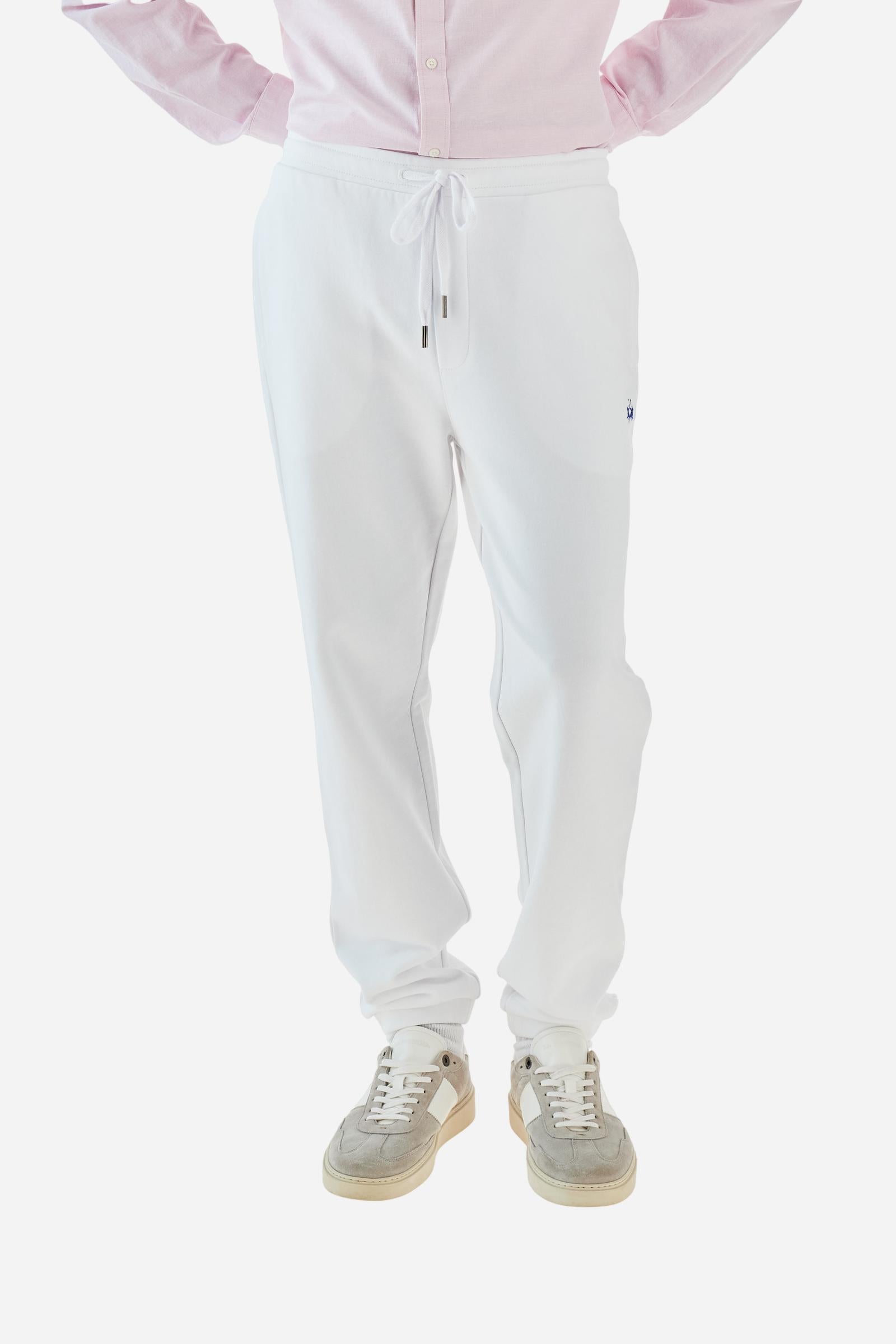 Single-colour men's jogging trousers in a French terry cotton sweat fabric. Removable and adjustable waistband with drawstring. American pockets at the sides. An additional patch pocket is applied on the back. The logo is embroidered in a colour-contrasting thread on the front, left side. The fit is regular. The model is wearing a size L. - Optic White