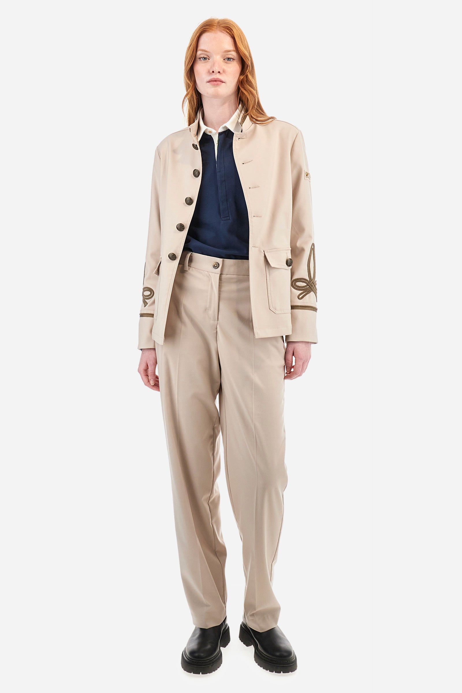 Women's long-sleeved Guards jacket, made from plain synthetic fabric. High neck. Button fastening. Decorations representing the Royal Guards line appear on the sleeves. Double pocket on the front, fastened with buttons. Belt loops at the waist. Regular fit. The model is wearing a size 42. - White Pepper