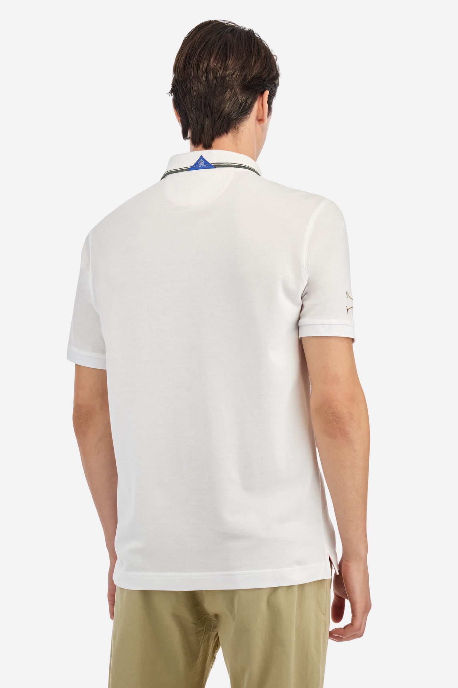 Men's short-sleeved Guards polo shirt in a single colour, made of cotton piqué. Fastens with two buttons. The collar is ribbed with striped trim in a contrasting colour. The graphics on the chest and sleeves are all made using the embroidery technique. The central lettering on the chest is a 3D embroidery in the same colour as the base fabric. The large colour-contrasting logo is embroidered on the chest. The fit is regular. The model is wearing a size L. - Optic White