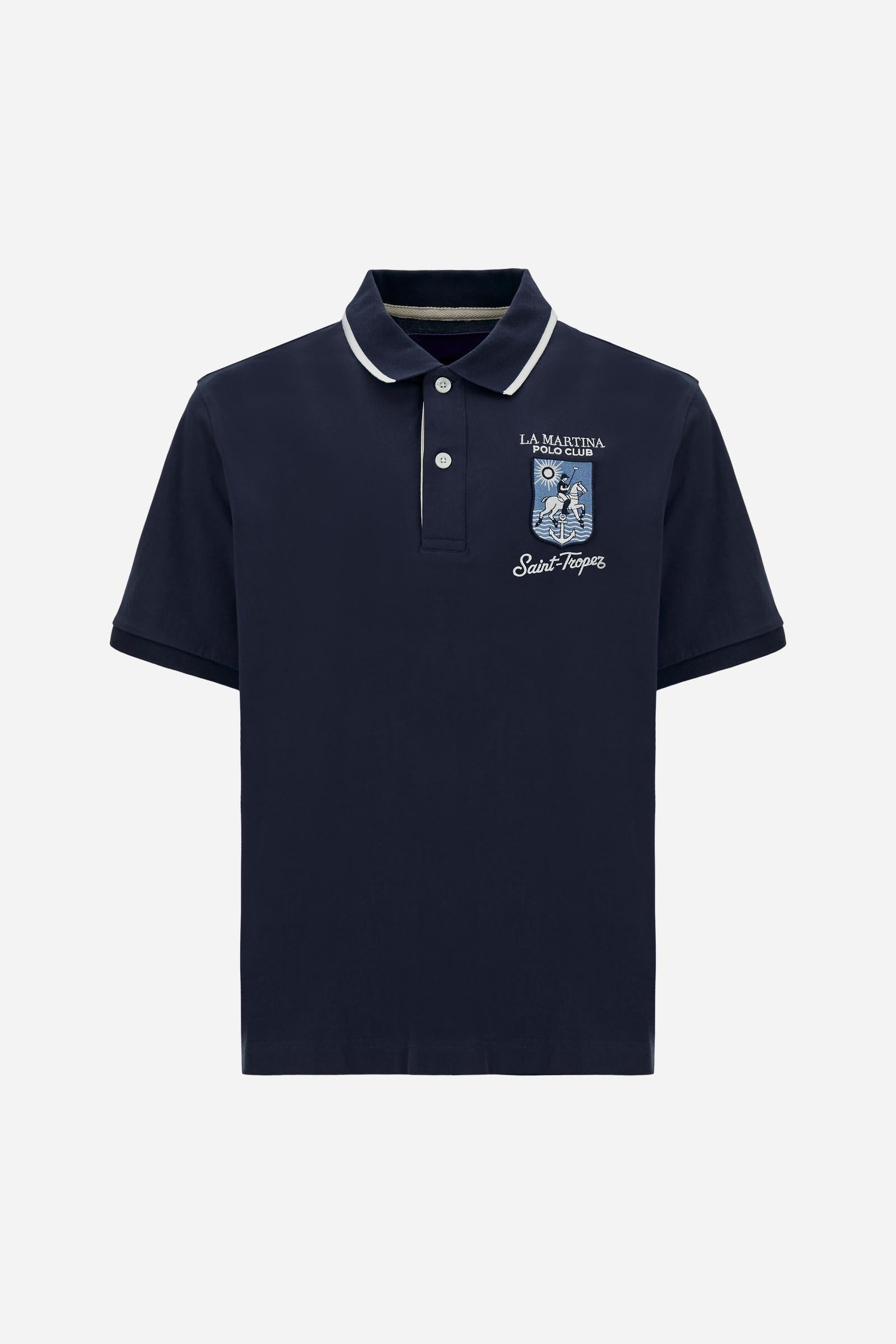 Men's short-sleeve polo shirt made from heavy-weight cotton jersey in solid color. The model features a front opening in contrasting jersey with vertically embroidered chain stitching. The collar and cuffs are ribbed with contrasting edge detail. The design is enriched with an embroidered crest on the chest dedicated to Saint Tropez and the iconic two polo players logo embroidered on the back. The fit follows modern trends with a slightly oversized silhouette, dropped shoulders and a relaxed shape. The mode