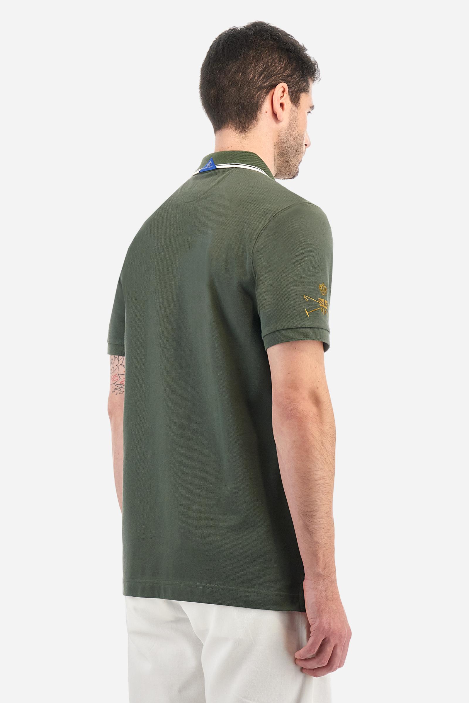 Men's short-sleeved Guards polo shirt in a single colour, made of cotton piqué. Fastens with two buttons. The collar is ribbed with striped trim in a contrasting colour. The graphics on the chest and sleeves are all made using the embroidery technique. The central lettering on the chest is a 3D embroidery in the same colour as the base fabric. The large colour-contrasting logo is embroidered on the chest. The fit is regular. The model is wearing a size L. - Thyme