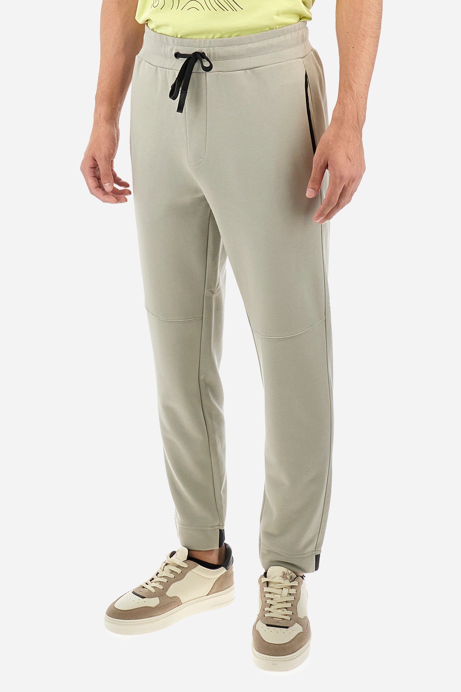 Men's single-colour jogging bottoms in a cotton sweat fabric. With a drawstring waist and double front pocket. With different shades at the bottom of the leg. On the back there is a pocket with a zip fastening featuring contrasting textures and colours. The logo is present on the tag sewn on the back pocket. The fit is regular. The model wears a size L. - Pussywillow Grey