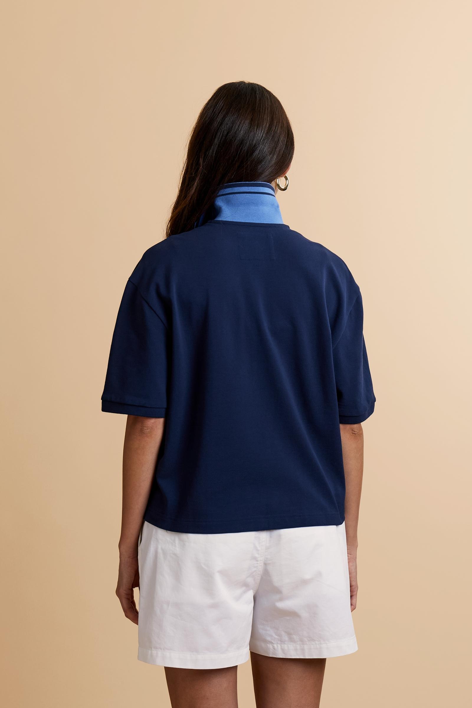 Women's short-sleeve polo shirt made from 100% cotton piqué fabric in solid color. The model features a front opening with customized buttons and a contrasting inner placket. The ribbed collar is two-tone with a striped detail creating a positive/negative color effect between the upper and lower parts. The modern fit features a slightly boxy cropped cut. The chest is decorated with a maxi 3D embroidered logo in contrasting color. The model is wearing size 2. - Navy