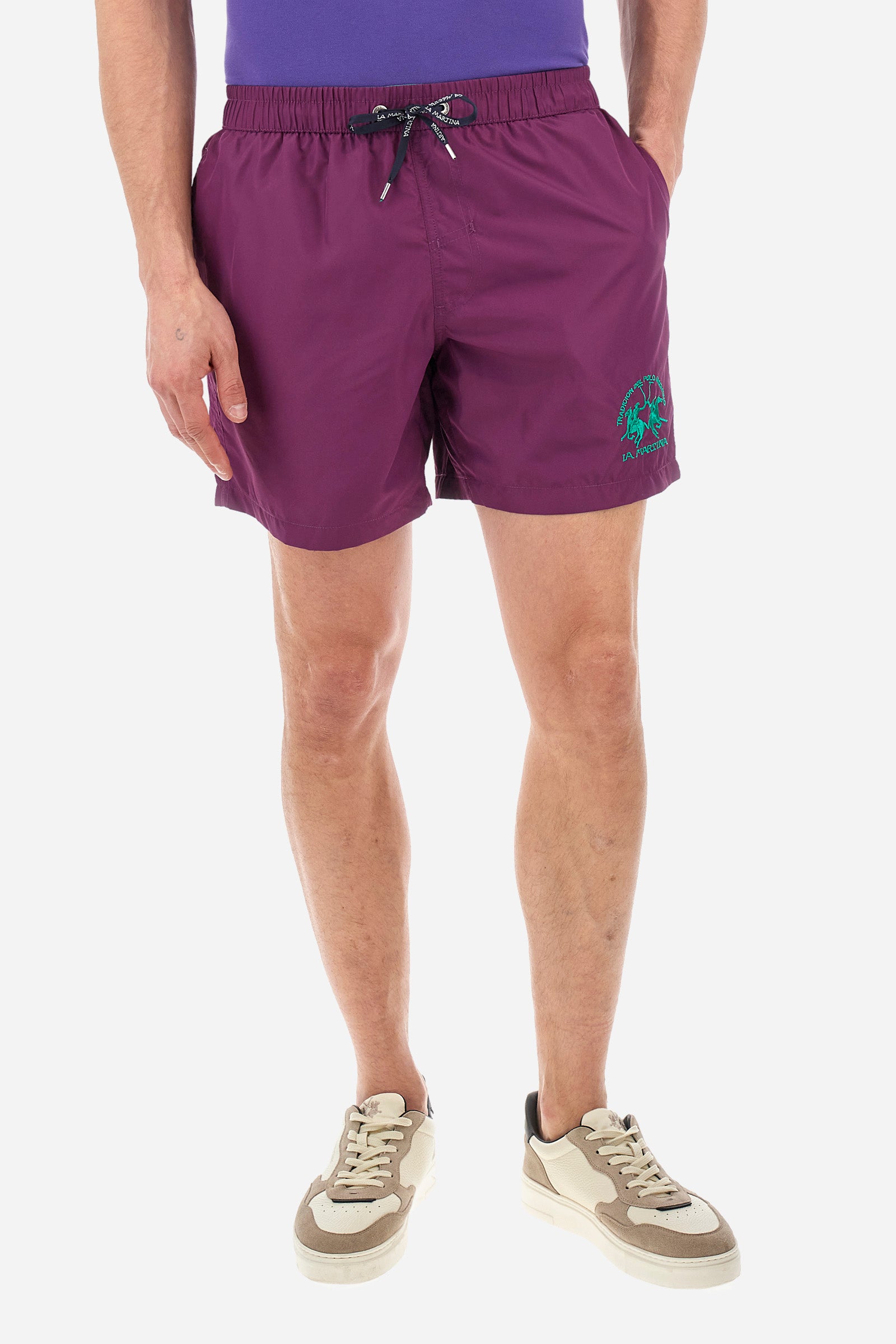 Single-colour men's swimming shorts, made of synthetic fabric. Featuring a drawstring and tie with "La Martina" lettering. Double welt pocket on the front. Closed pocket on the back. Mesh lining. Large logo embroidered on the front. The fit is regular. The model wears a size L. - Gloxinia