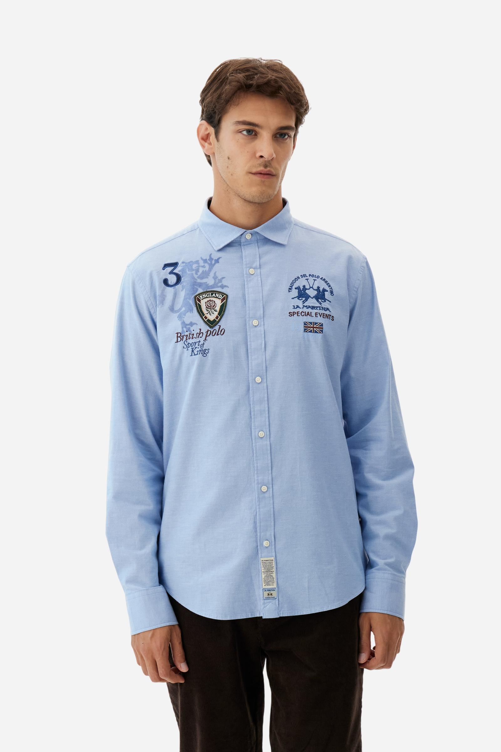 Classic men's long-sleeved shirt in stretch cotton Oxford, solid colour. Finished with a French collar and interior regimental-pattern fabric details. Chest features multicolour prints and embroideries inspired by British Polo, including the large team logo embroidered in contrast. Regular fit ensuring comfort and enhancing any physique. Model wears size L. - Cornflower blue