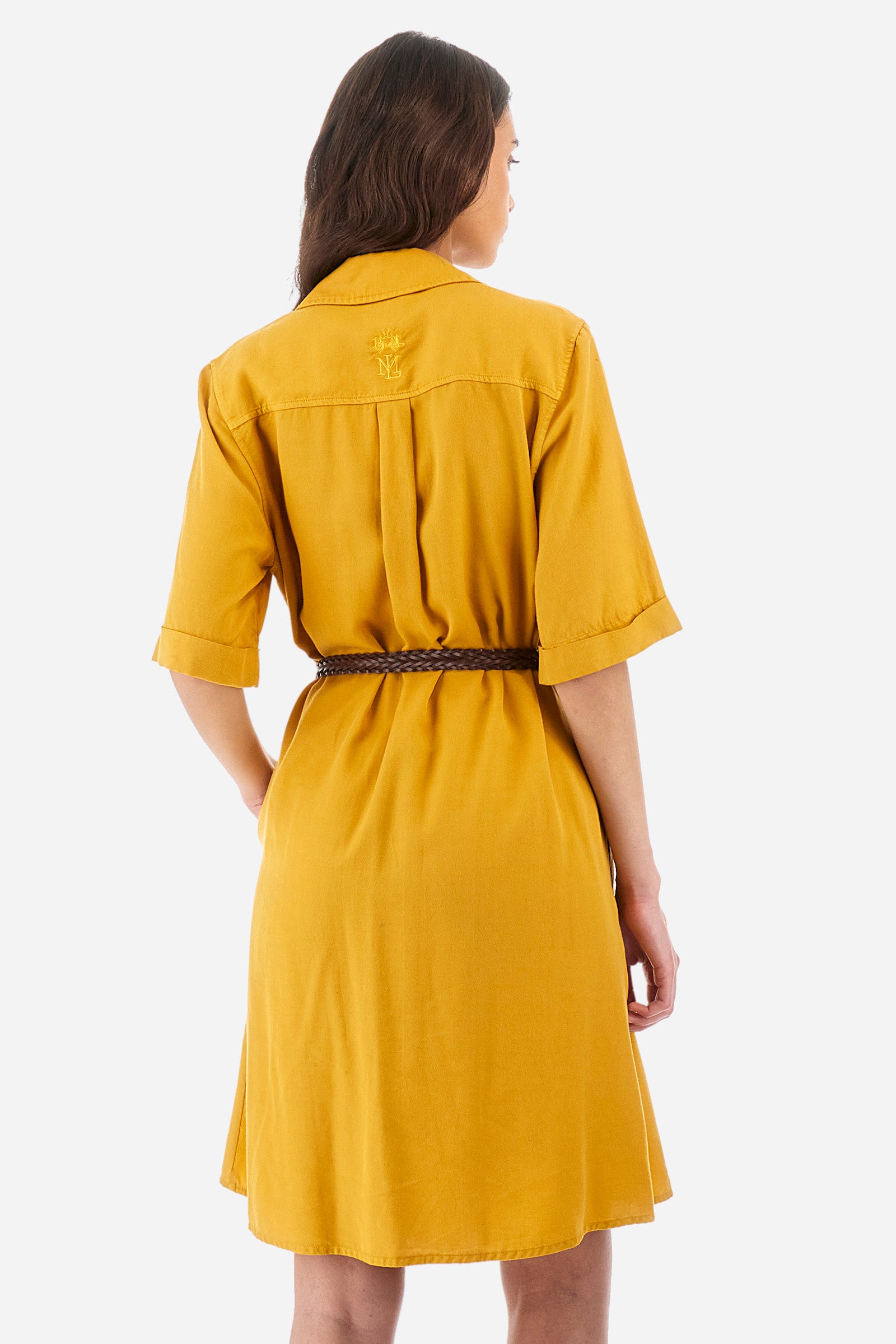 Women’s short-sleeved dress in solid color, made of twill tencel fabric. Flared silhouette, length above the knee. Waist marked by the belt supplied with the head, England capsules. V-neck and button closure. Two front pockets, also with button closure. On the back embroidery of La Martina logo tone on tone. The fit is regular. The model wears a size IT40. - Arrowwood