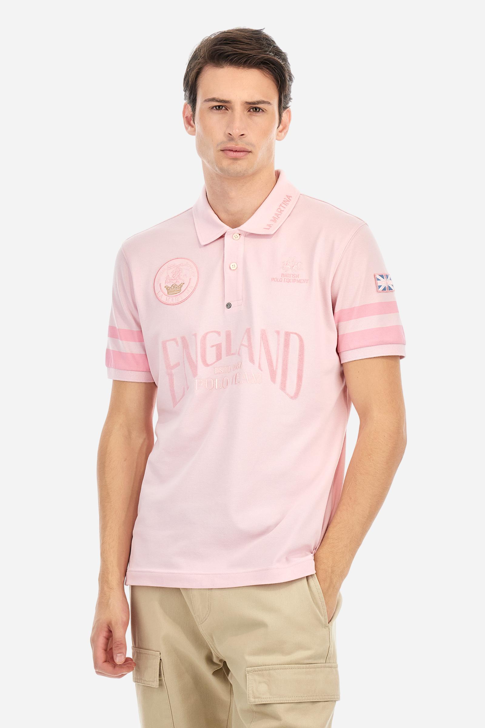 Short-sleeved, single-colour men's polo shirt made of stretch cotton piqué. Fastens with two buttons. Sleeve details in fabric with colour-contrasting irregular band pattern. Ribbed collar with brand name embroidery in contrasting colour. The front graphics are embroidered, the large central lettering is a flocked transfer, while the flag on the sleeve is an applied patch. The logo is embroidered on the chest, left side. The fit is regular. The model is wearing a size L. - Parfait Pink