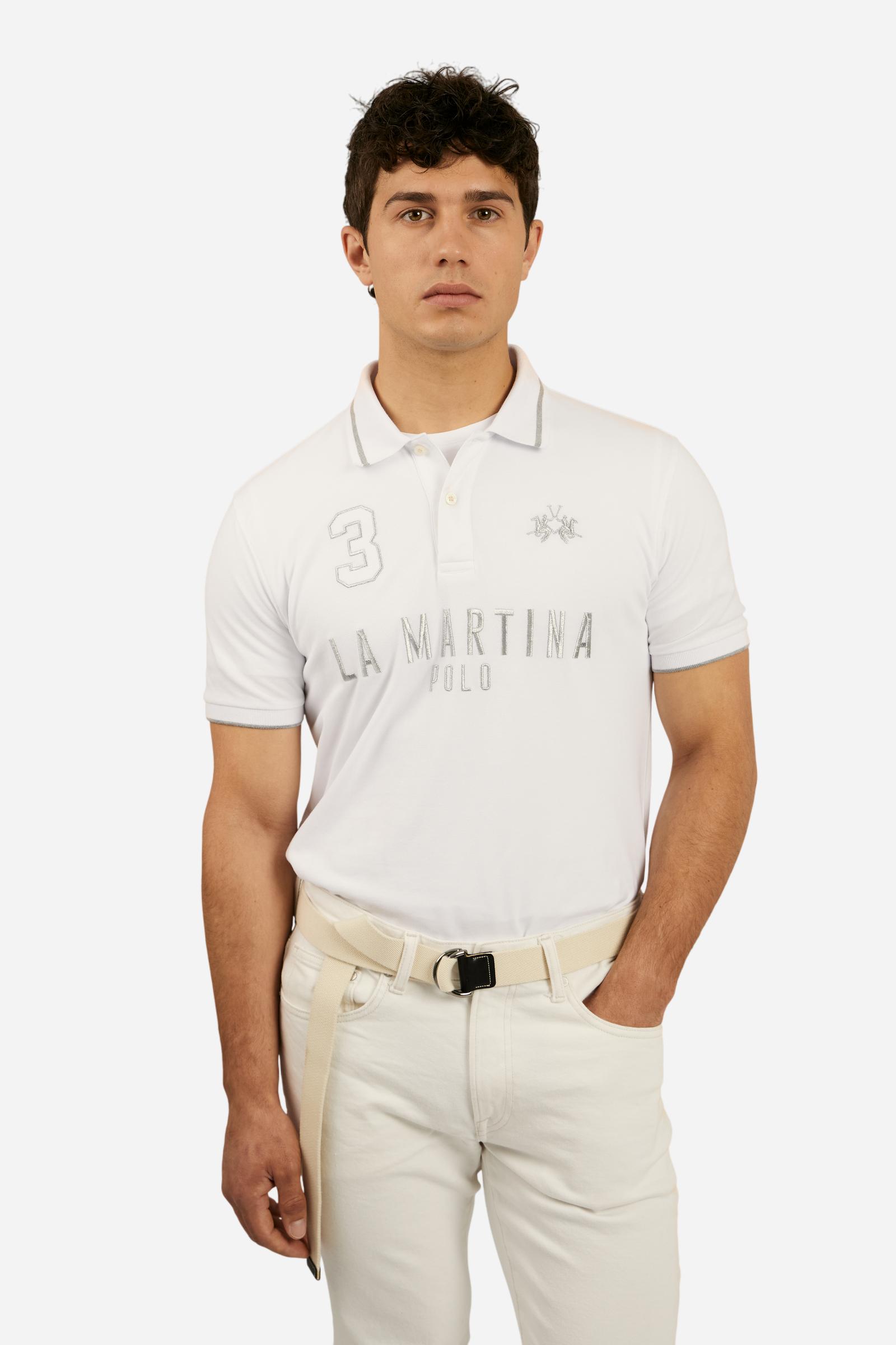 Men's plain short-sleeved polo shirt made from stretch piqué. Two-button fastening. The collar and cuffs are made from ribbed fabric with narrow contrasting trim at the bottom. The large La Martina Polo lettering on the chest is embroidered in contrasting thread. The number 3 patch appliquéd on the right side of the chest and the logo on the left side are also embroidered using contrasting thread. Regular fit. The model is wearing a size L. - Optic White