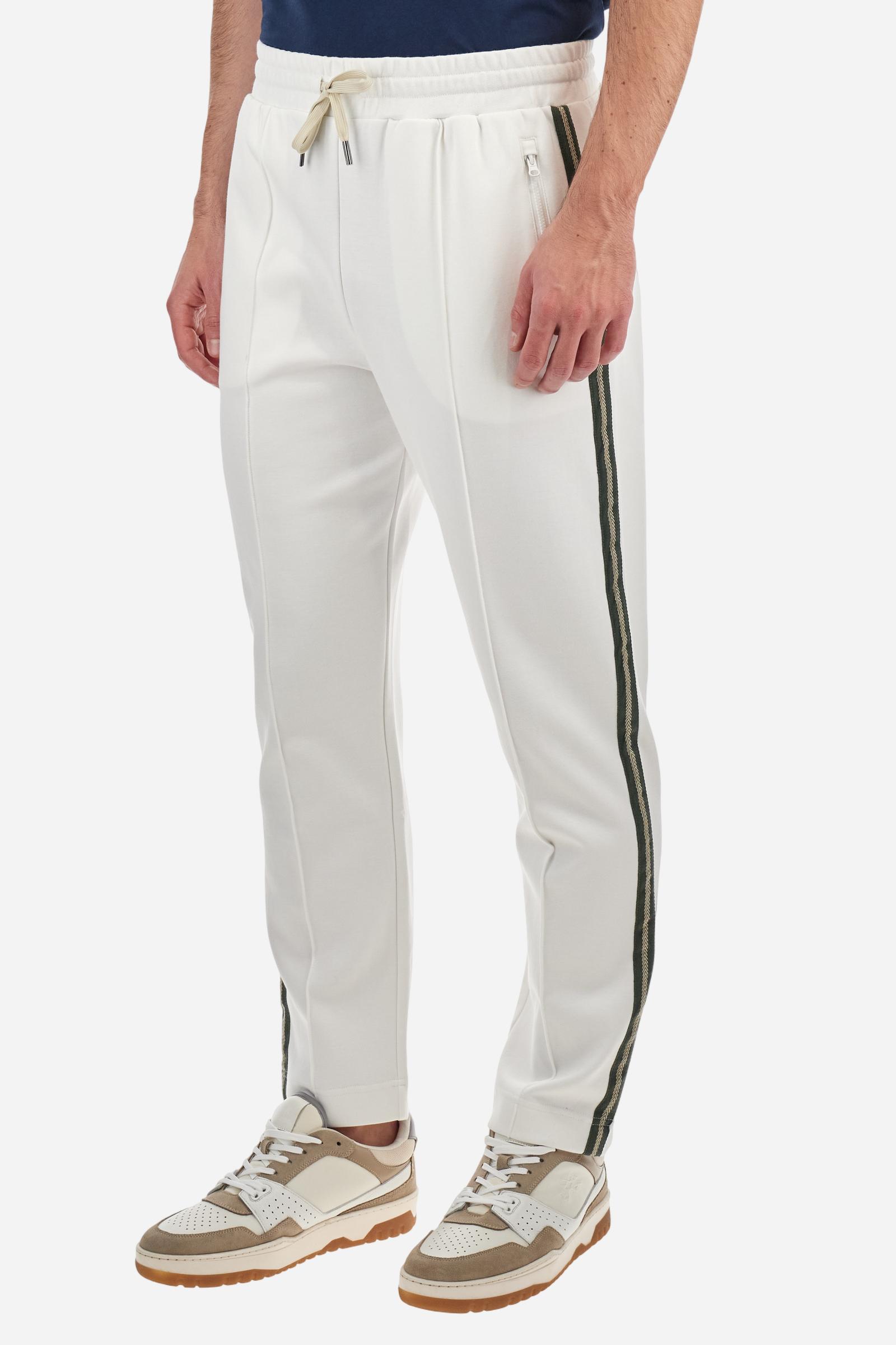 Single-colour men's jogging trousers made of lightweight cotton-blend interlock fleece. Drawstring waistband. Side pockets with matching zip fastening. On both sides, there are multicoloured striped jersey bands. The front features vertical ribbed detailing. The logo is embroidered in colour-contrasting thread on the back, under the strap, towards the right side. Regular fit. The model is wearing a size L. - Off White