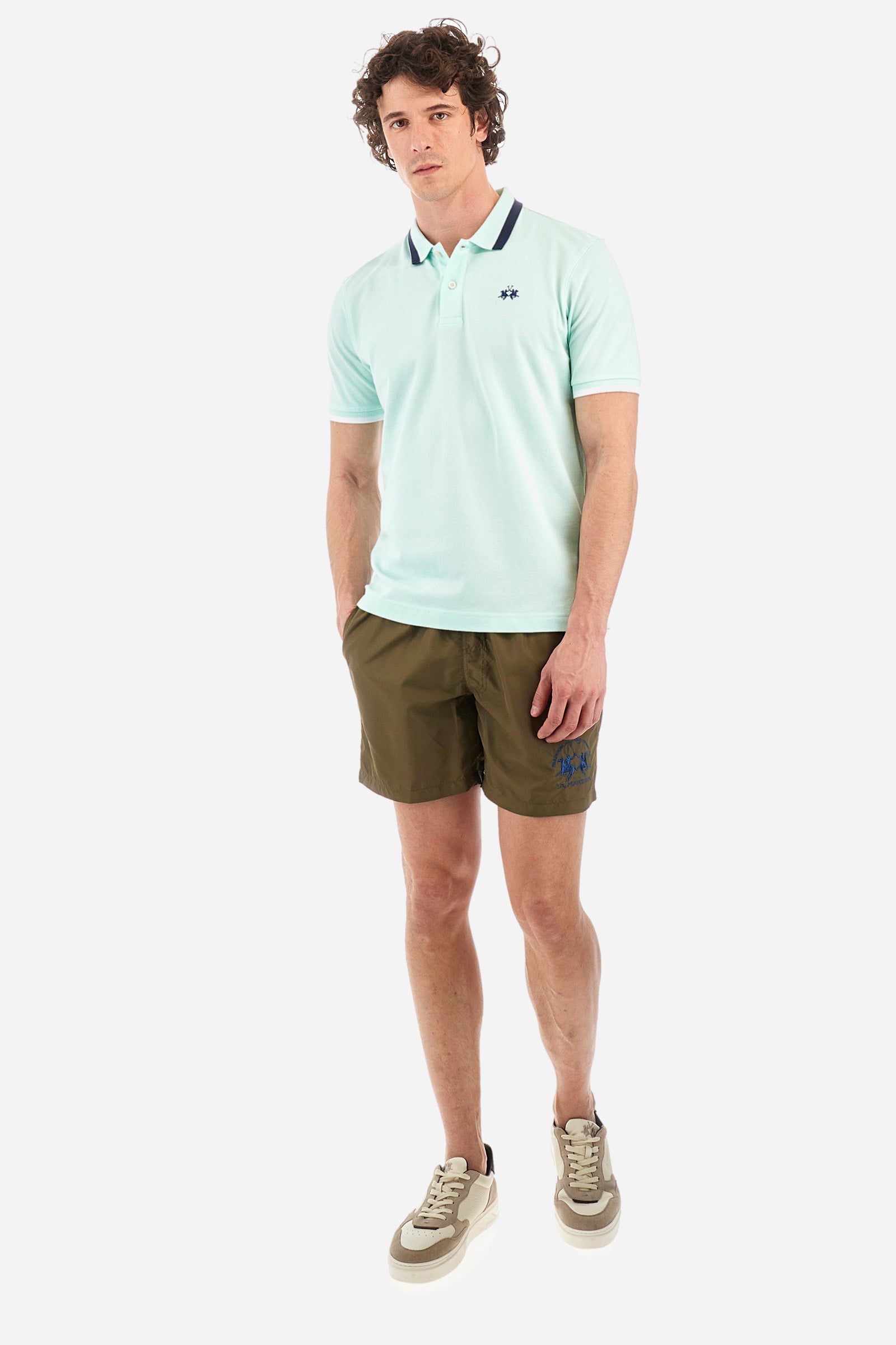 Men's single-colour short-sleeved polo in elasticated cotton. Two-button fastening. Ribbed collar and armholes with a stripe in different shades. The "La Martina" lettering can be found under the collar. Featuring a small logo embroidered on the chest. In a slim fit. The model wears a size L. - Honeydew