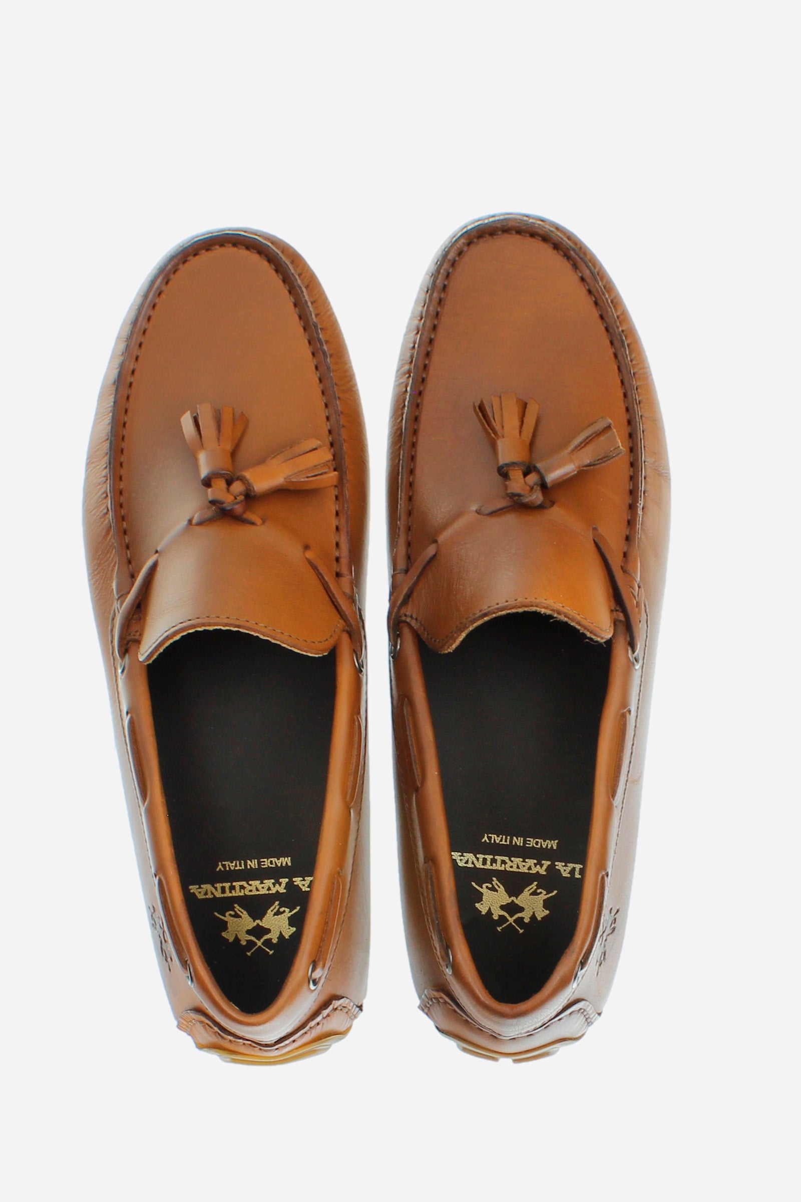Soft leather loafer with a cord inspired by the boat shoe, ideal for an elegant and casual style. The sole with rubber tread guarantees grip and performance. The tonal cord with tassels, knotted on the vamp and threaded through metal eyelets, embellishes the design. The logo is embossed on the back. The hand stitching on the vamp and custom footbed reflect the craftsmanship of the shoe, ensuring a comfortable and refined fit. - COGNAC