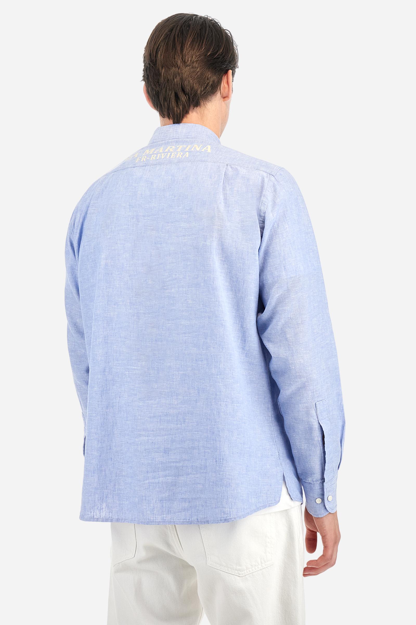 Men's plain long-sleeved shirt, made from luxurious cotton and linen canvas. The spread collar and the opening, which reaches the waist, are closed with 4 buttons. The left bicep is embellished with embroidered graphics depicting lettering, crests and numbers, created using contrasting thread. The logo is embroidered in contrasting thread on the left side of the chest. The regular fit offers a refined and comfortable look. The model is wearing a size L. - Cornflower blue