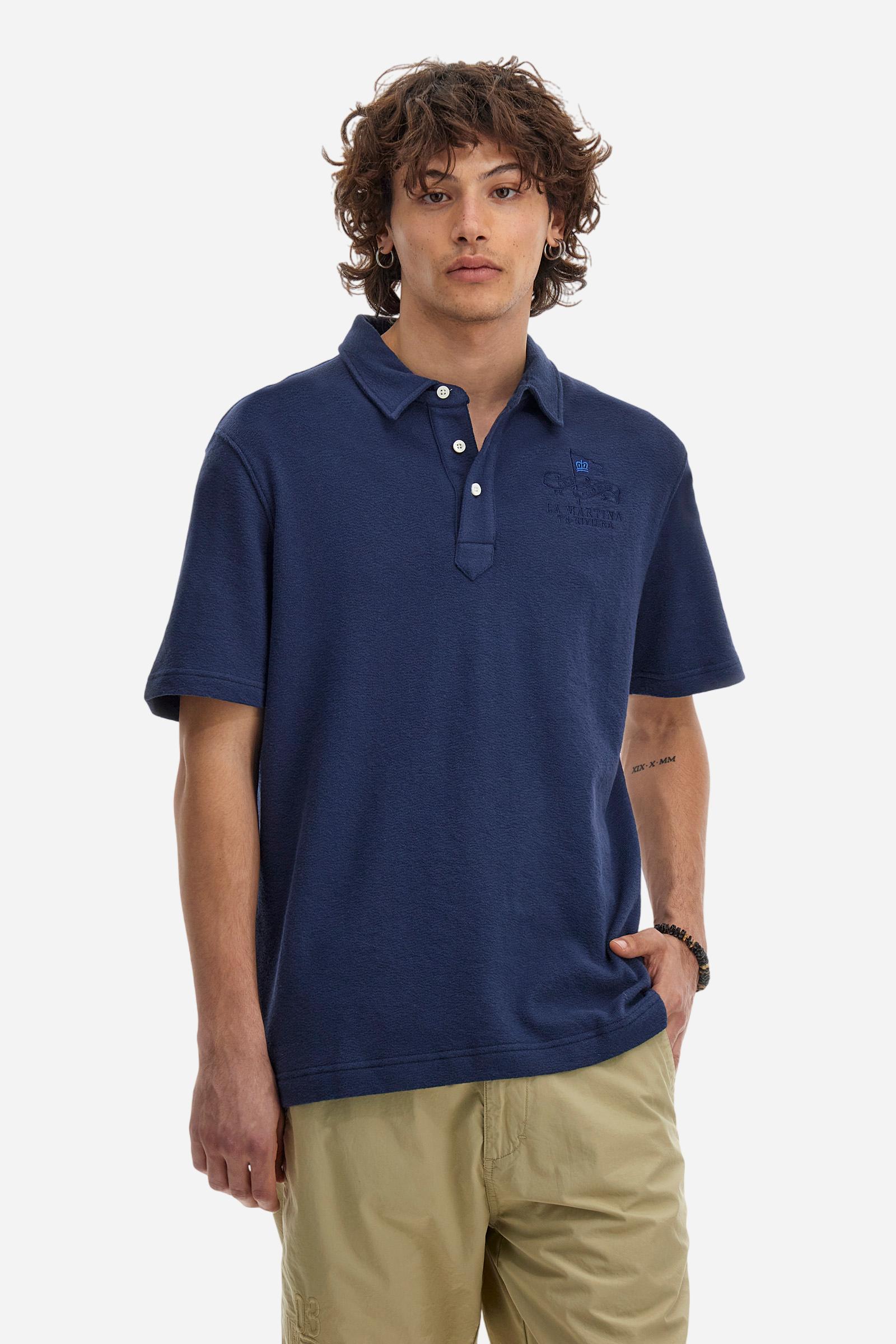 Men's plain short-sleeved polo shirt made from brushed jersey. Three-button fastening. The embroidery on the left side of the chest, in contrasting thread, is inspired by the French Riviera. A small logo is embroidered on the left sleeve, also using contrasting thread. Regular fit. The model is wearing a size L. - Navy