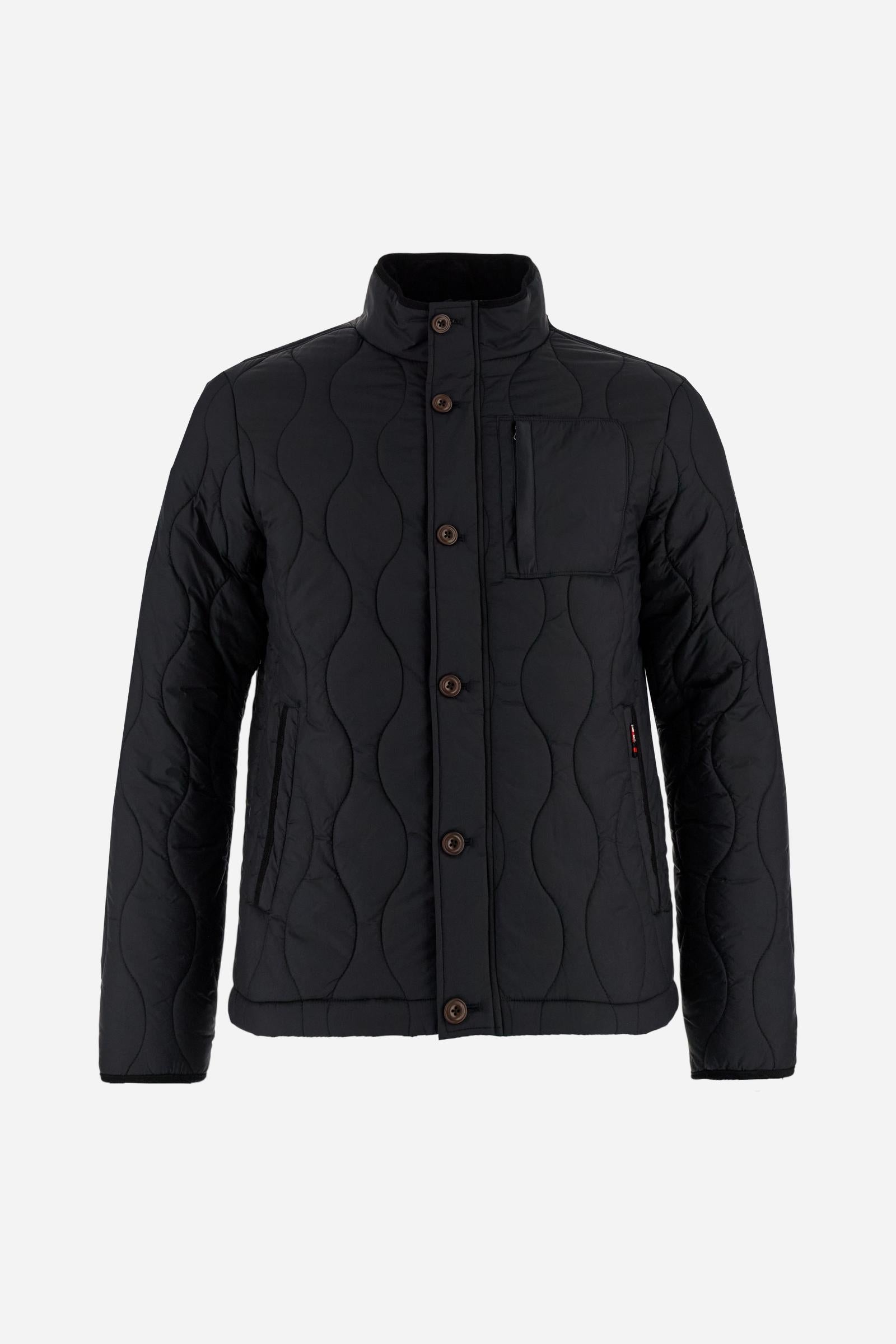 Men’s quilted nylon husky jacket with high collar. Front closure with customized zip and large faux-leather buttons. Interior lined with striped bicolor polyester. Contrast details on the inside (pockets, profiles, back-neck tab). Clean design with chest pocket closed by zip and vertical side pockets. Adjustable back straps with metal snap buttons. Logo patches on the sleeves and multicolor embroidered lettering on the outer collar. Part of the Guards capsule. Regular fit. Model wears size L. - Black