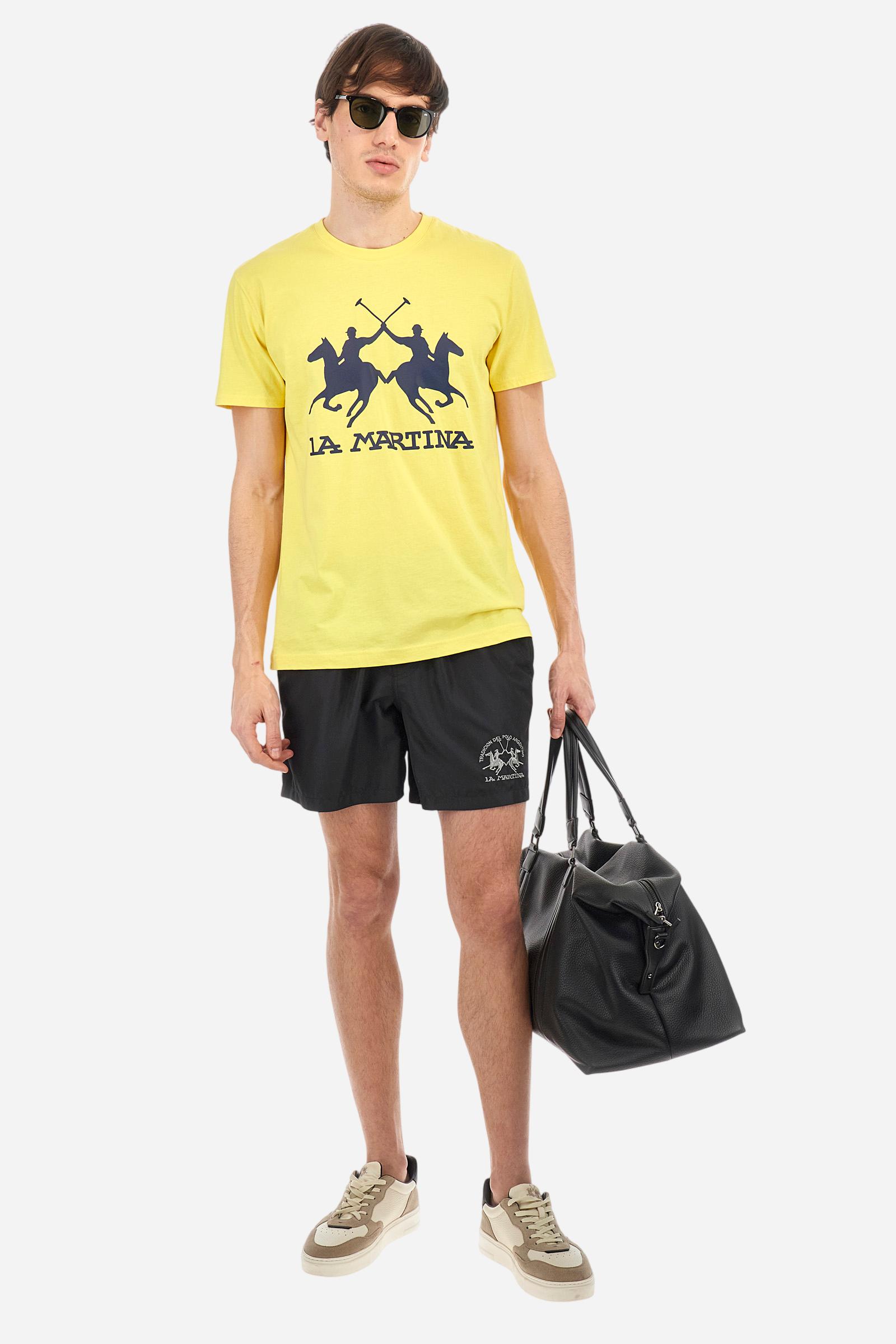 Plain men's swimming shorts made of nylon. Elastic waistband with a personalised drawstring for waist adjustment. On the inside of the shorts is an elasticated mesh brief. Double side pocket on the hips and patch pocket with flap on the back, on the right side only. The large logo is embroidered in a contrasting colour thread on the bottom of the left leg on the front. Regular fit. The model is wearing a size L. - Black