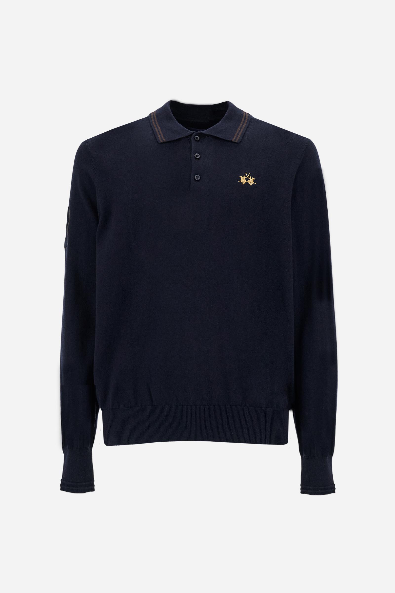 Men’s long-sleeved knitted polo in plain yarn blend (50% cotton, 50% wool), balancing comfort and warmth. Classic ribbed collar and cuffs with subtle contrasting stripe. Three personalized buttons on the placket. Small embroidered brand logo in contrasting color on the chest. On the right sleeve, a cord-embroidered number patch completes the design. Regular and slightly roomy fit. Model wears size L. - Navy