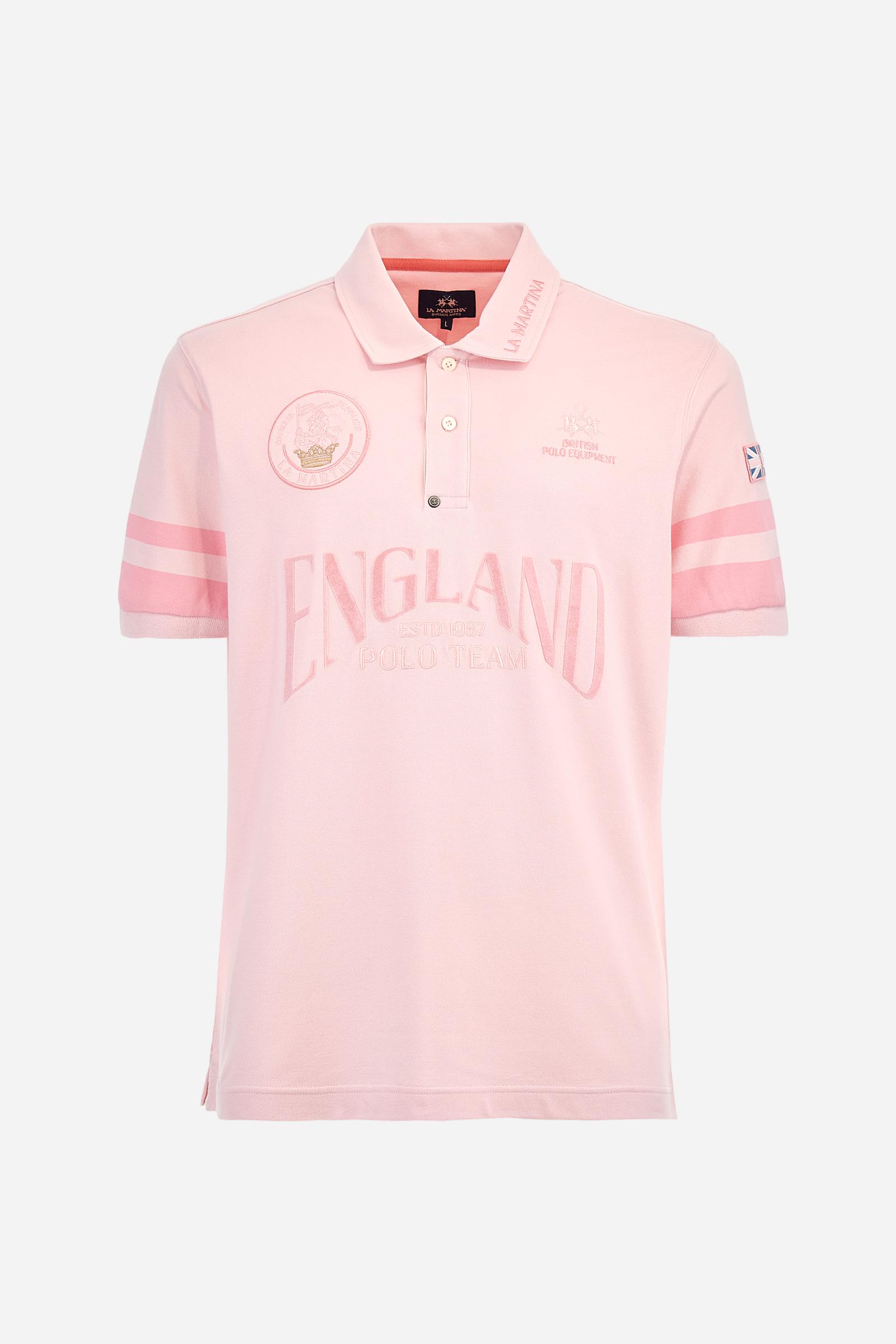 Short-sleeved, single-colour men's polo shirt made of stretch cotton piqué. Fastens with two buttons. Sleeve details in fabric with colour-contrasting irregular band pattern. Ribbed collar with brand name embroidery in contrasting colour. The front graphics are embroidered, the large central lettering is a flocked transfer, while the flag on the sleeve is an applied patch. The logo is embroidered on the chest, left side. The fit is regular. The model is wearing a size L. - Parfait Pink