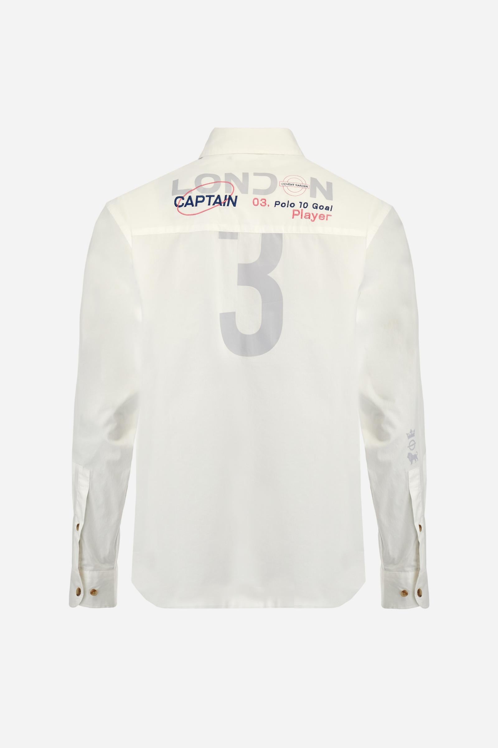 Men's single-colour long-sleeved shirt, made from 100% cotton poplin. Spread collar. Contrasting printed fabric details on the inside of the collar and opening. The numbers on the chest and back graphics are rubberised prints, while the rest of the graphics are embroidered. The logo and La Martina lettering is embroidered on the left chest. The fit is regular. The model is wearing a size L. - Optic White