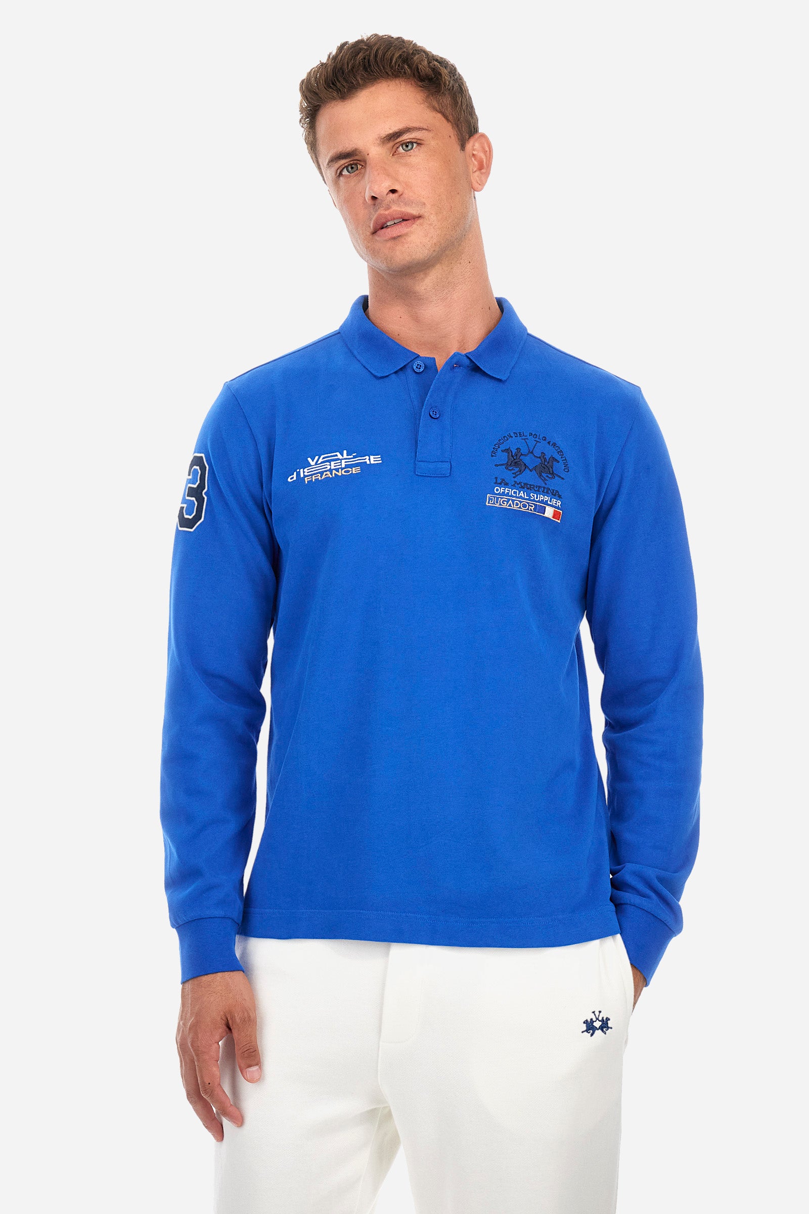 Men's single-colour long-sleeved polo shirt, made from 100% cotton. Two-button fastening. Featuring the logo and lettering embroidered on the front. Regular fit. The model is wearing a size L. - Classic Blue