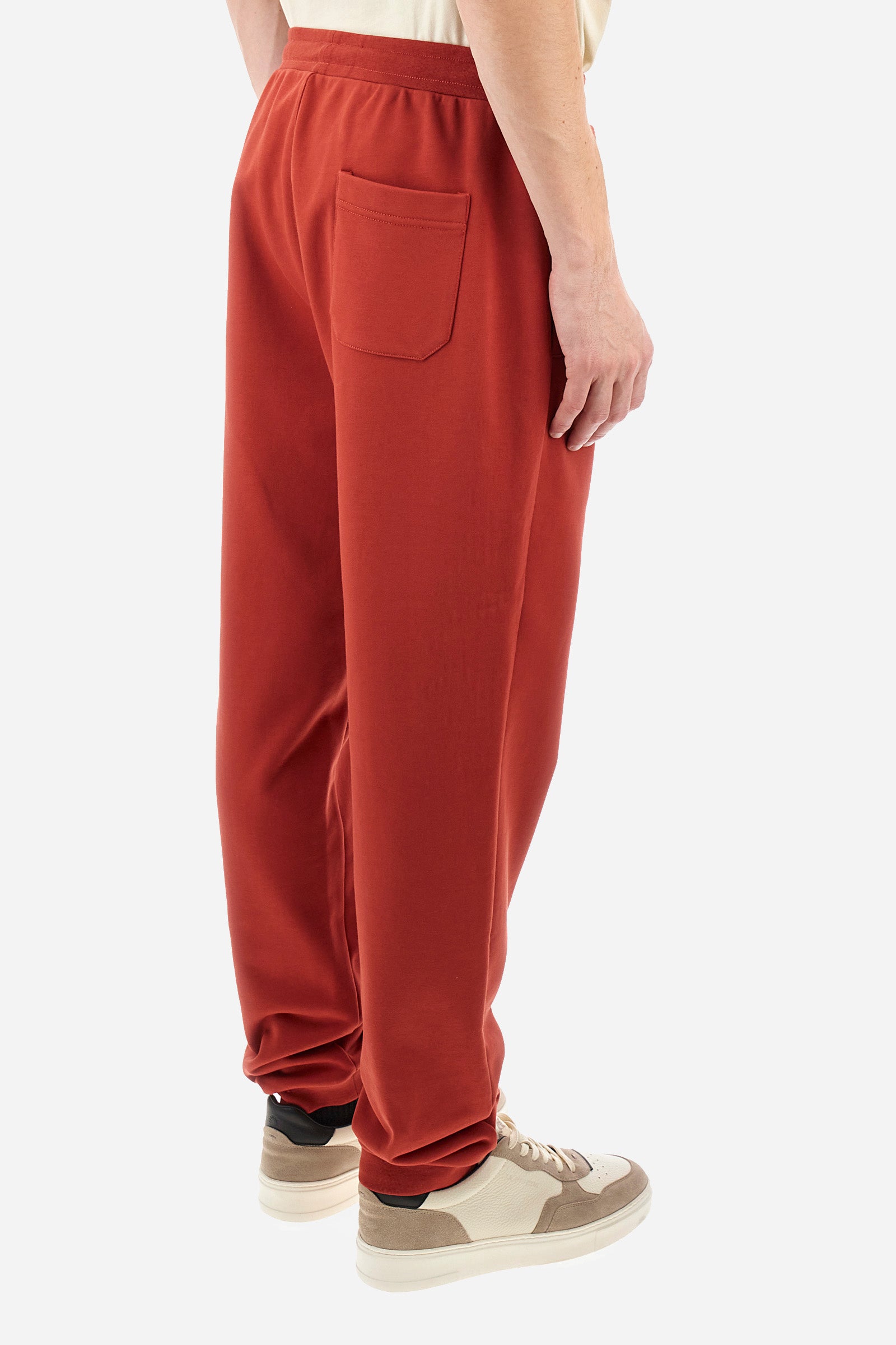 Men's single-colour jogging bottoms in a cotton sweat fabric from the Polo Academy line. With a drawstring waist and double front pocket. Another pocket is present on the back. The logo is present on a patch applied under one of the front pockets. The fit is regular. The model wears a size L. - Cinnabar
