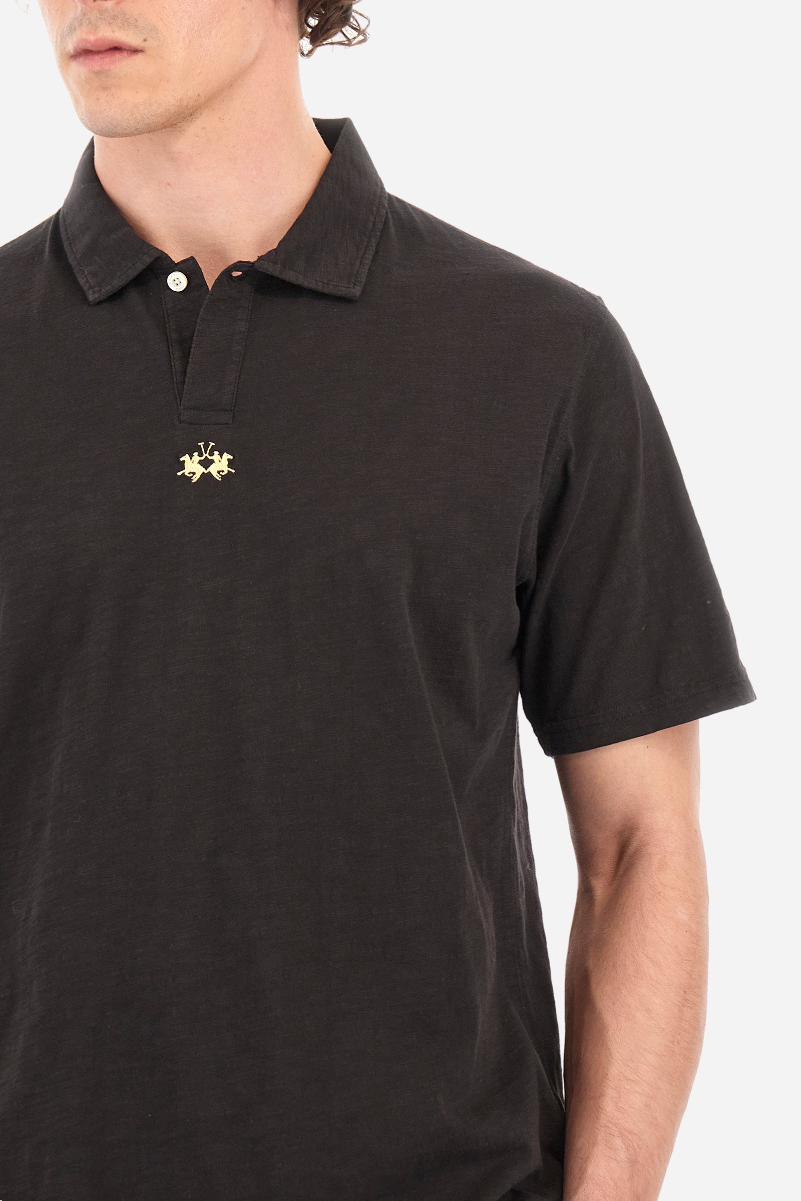 This is the iconic Polo 19-42 from La Martina. Men's short-sleeved polo shirt in solid color made of 100% slub jersey. With a regular fit, it has a collar and a double button closure while the La Martina logo is embroidered in small gold on the front under the placket. Ideal when worn with denim from the collection. Each Polo is kept in an exclusive logoed envelope and is accompanied by a certificate of guarantee. The model is 187 cm tall and wears a size L. - Black