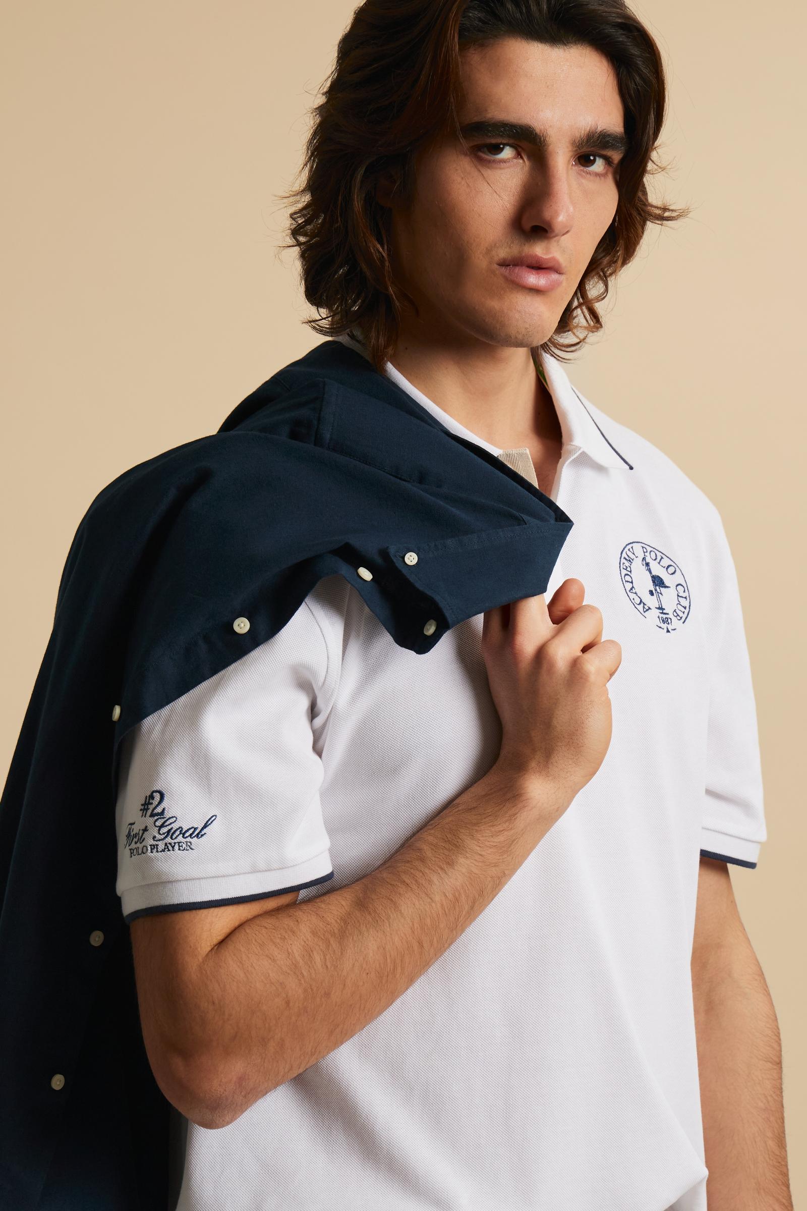 Piqué cotton polo with classic collar and contrast details. Graphic embroidery on chest and sleeves, including the “Academy Polo Club” crest. Modern clean fit. - Optic White