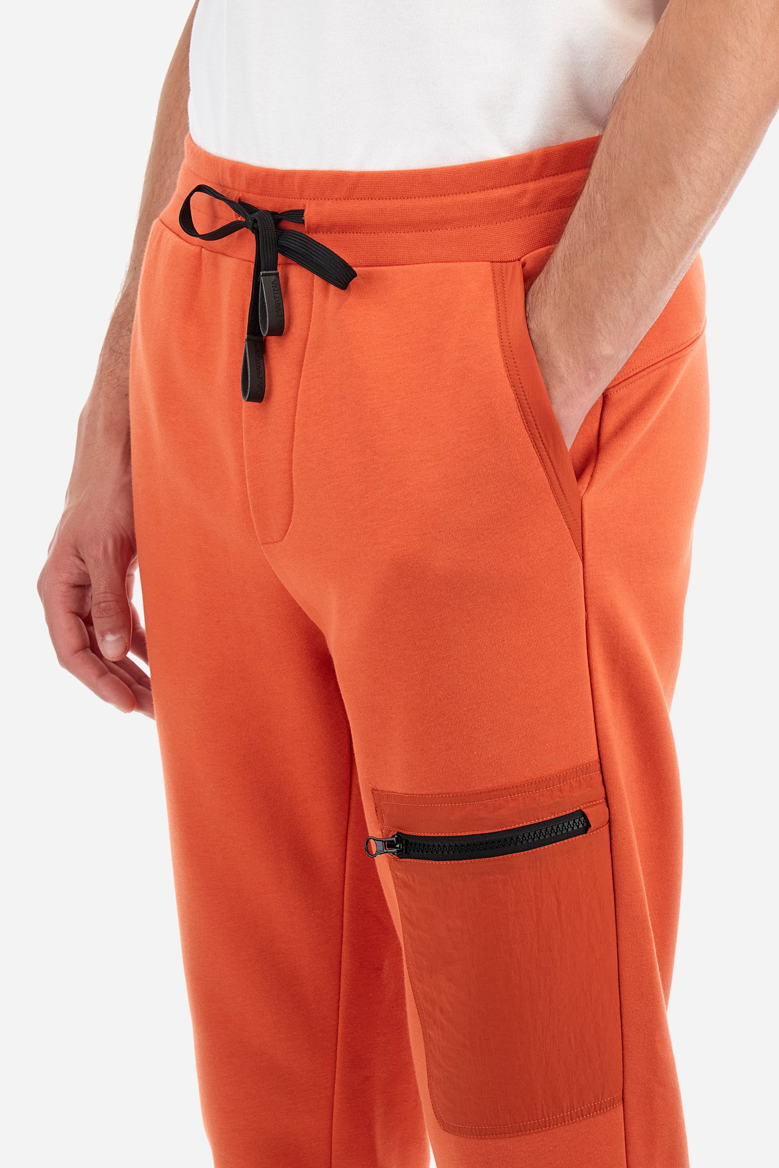 Men's plain jogging bottoms, made from a cotton blend. Drawstring waist and cuffs. Double front pocket. There is an additional zipped pocket on the front. The logo appears on an appliquéd plaque the back. Regular fit. The model is wearing a size L. - Pureed Pumpkin