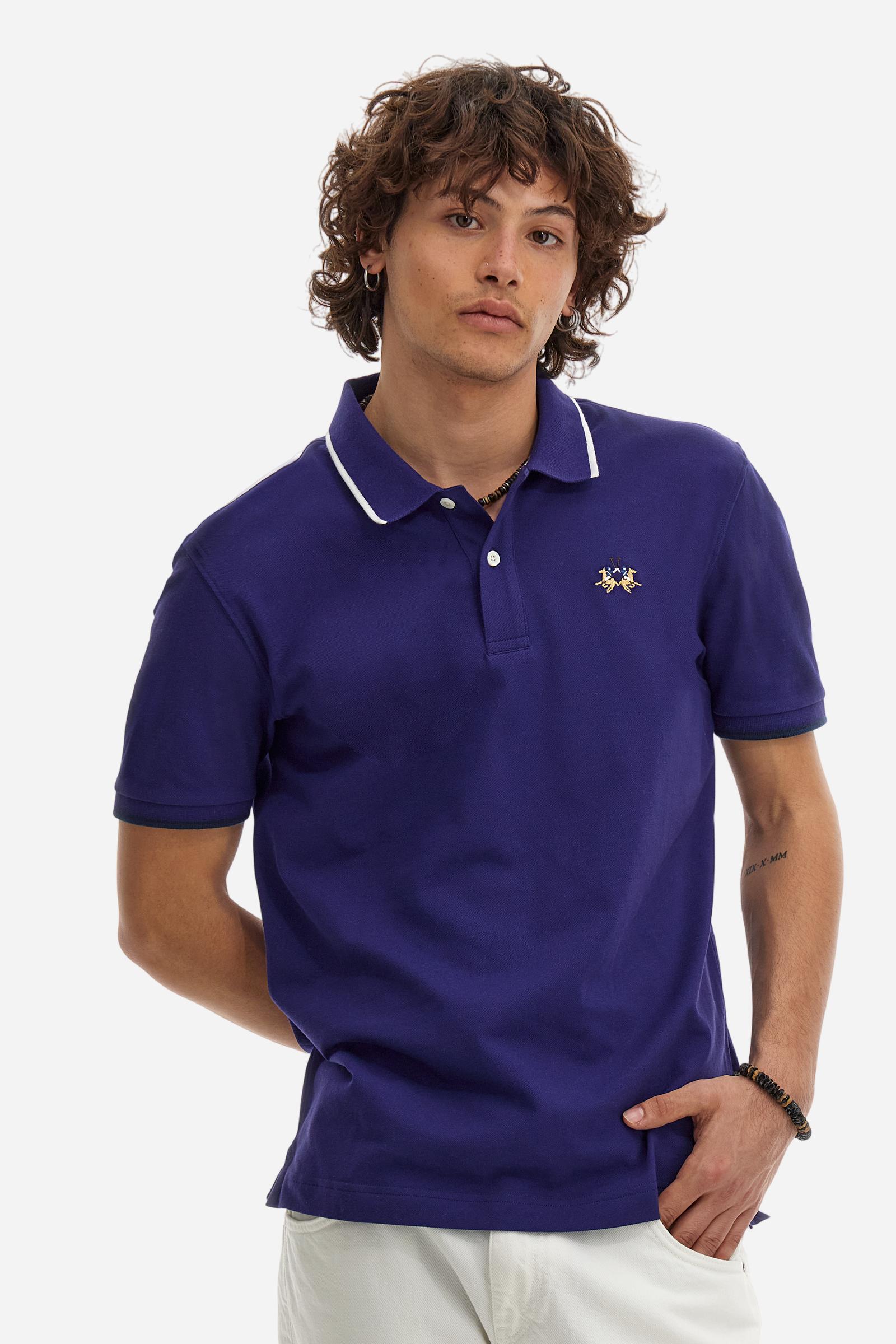 Short-sleeved, single-colour men's polo shirt made of stretch cotton piqué. Fastens with two buttons. The collar and cuffs are ribbed, and there is a colour-contrasting trim at the bottom of the collar. Inside the collar there is a grosgrain ribbon of a different shade. The logo is embroidered on the chest in a contrasting colour. The fit is slim. The model is wearing a size L. - Deep Cobalt