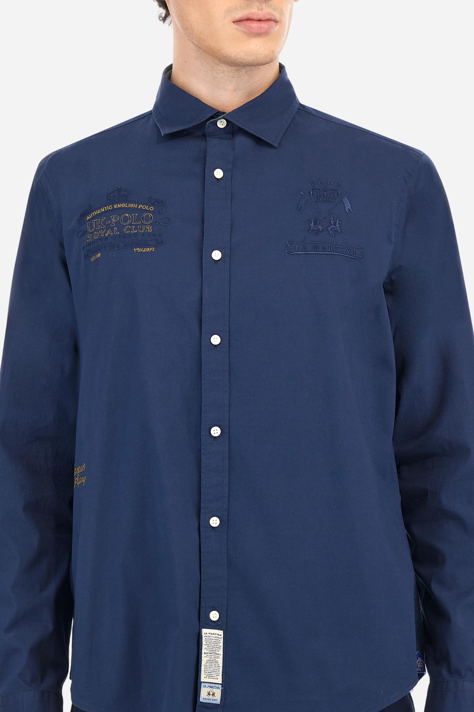 Men's single-colour long-sleeved shirt, made from 100% cotton poplin. Spread collar. Featuring details inside the collar and cuffs in contrasting colours and fabrics. The front graphics and logo are embroidered with contrasting colour threads. The fit is regular. The model is wearing a size L. - Navy
