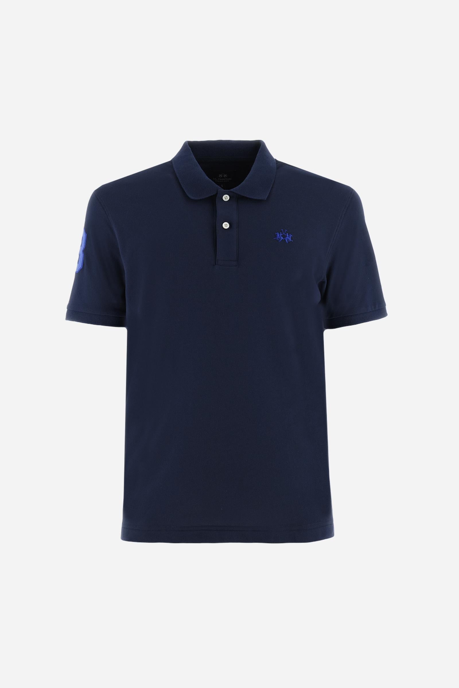 Men's plain short-sleeved polo shirt made from stretch piqué. Two-button fastening. The collar and cuffs are made from tone-on-tone ribbed fabric. A contrasting fabric patch depicting the number 3 is appliquéd on the right sleeve. The logo is embroidered on the left side of the chest in contrasting thread. Under the collar, there is a large contrasting print of the La Martina lettering. Regular fit. The model is wearing a size L. - Navy