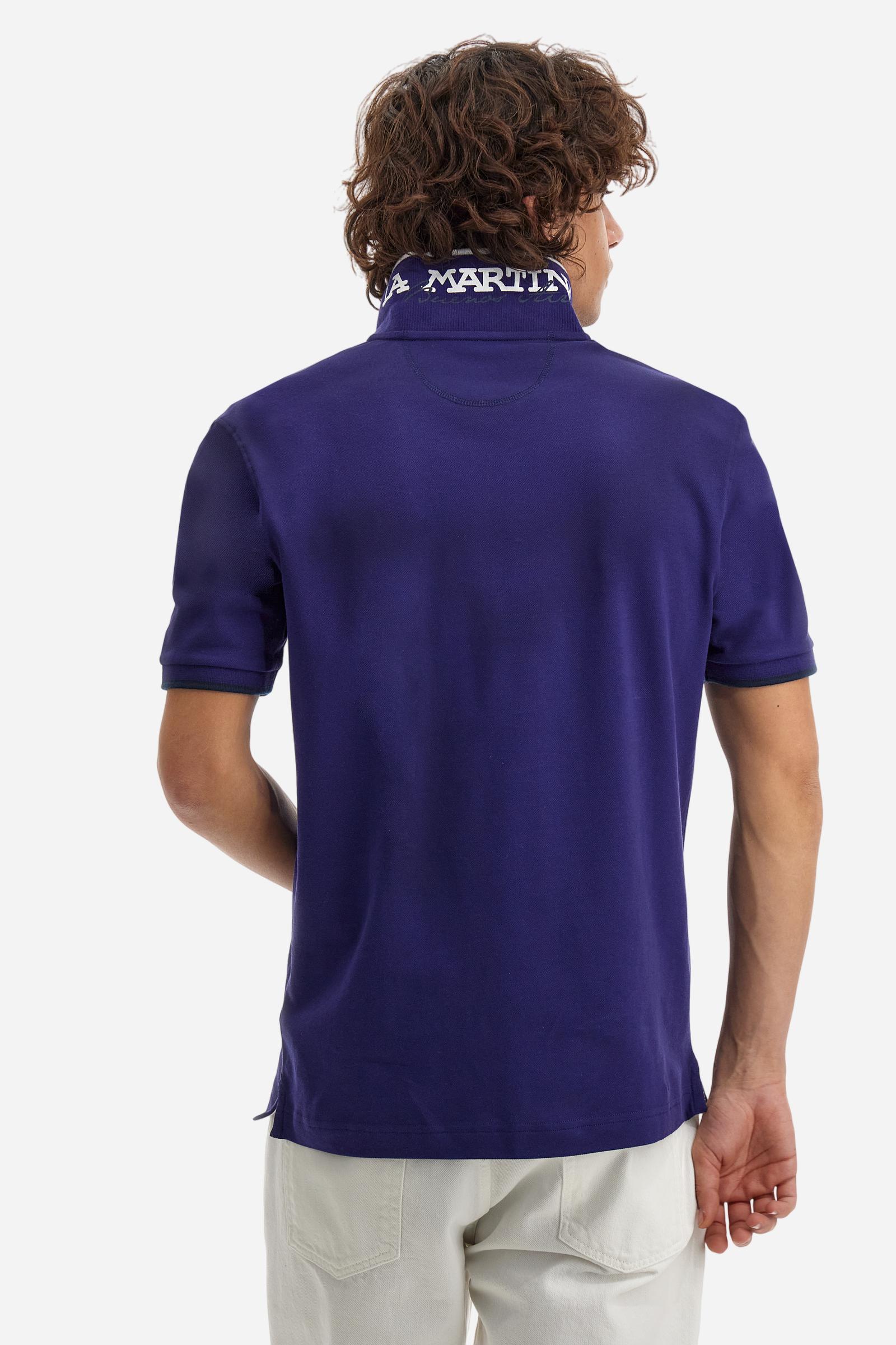 Short-sleeved, single-colour men's polo shirt made of stretch cotton piqué. Fastens with two buttons. The collar and cuffs are ribbed, and there is a colour-contrasting trim at the bottom of the collar. Inside the collar there is a grosgrain ribbon of a different shade. The logo is embroidered on the chest in a contrasting colour. The fit is slim. The model is wearing a size L. - Deep Cobalt