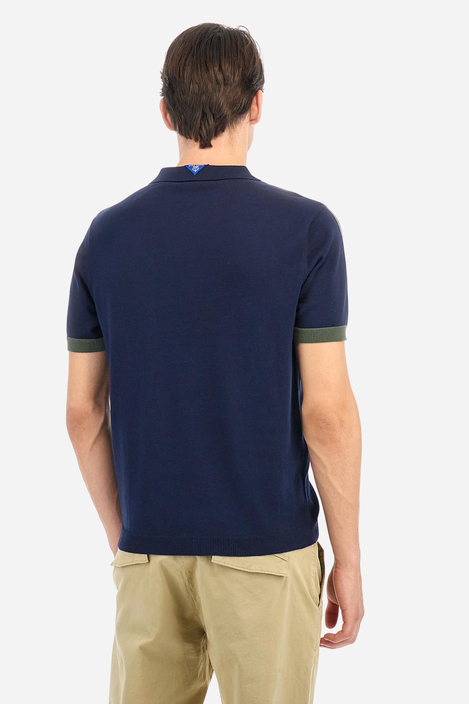 Men's two-tone short-sleeved knitted polo shirt made of 100% cotton. The cuffs are contrasting, while the waistband is in the same tone, but both are ribbed. The applied bands on the sleeve and shoulders are knitted in a contrasting colour. Contrasting details are present on the neck opening and inside the collar as a decorative motif. Small embroidered lettering on the front. The logo is embroidered in a contrasting colour on the chest, left side. The fit is regular. The model is wearing a size L. - Navy