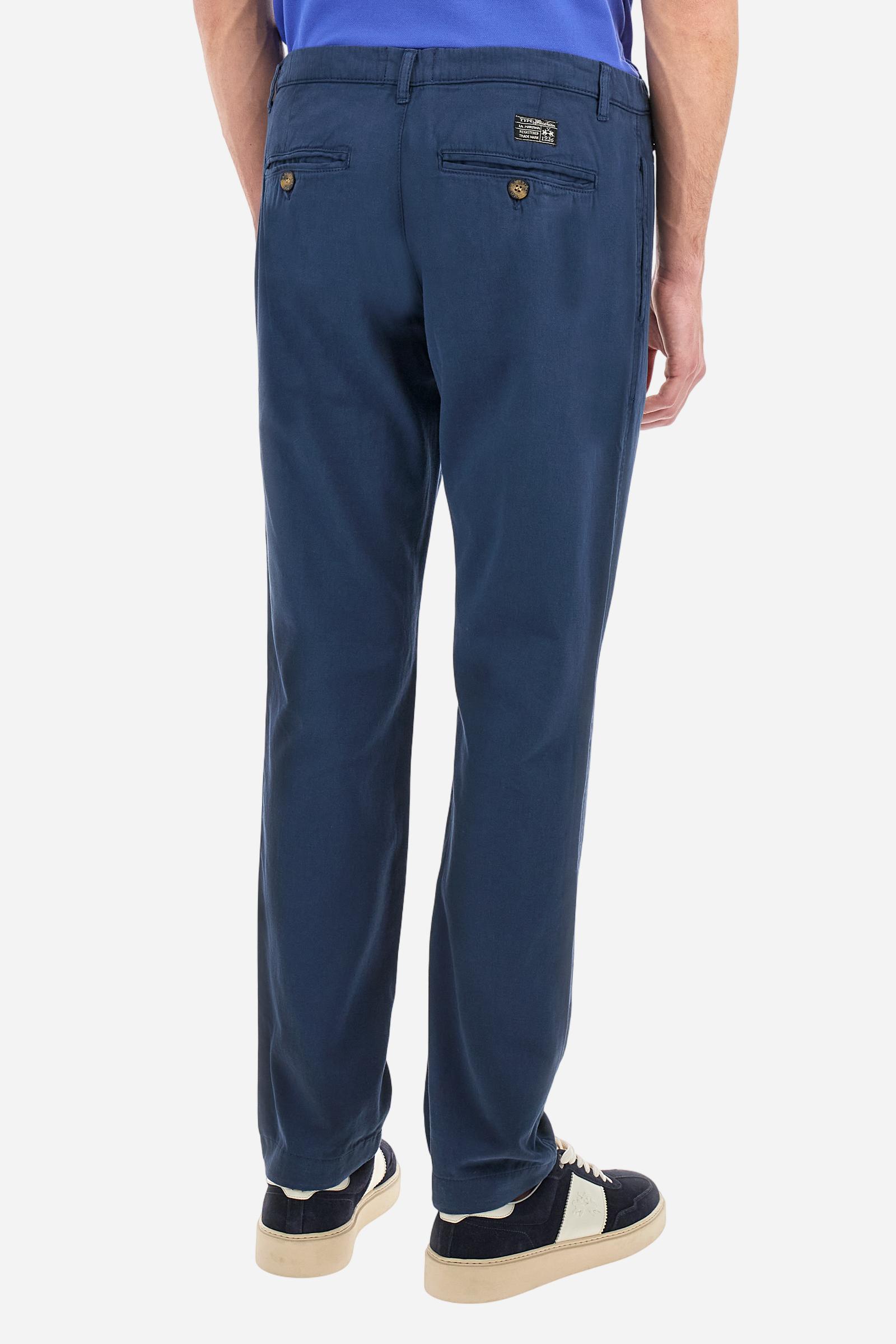Single-colour men's chino trousers made of cotton and linen canvas. Straight leg. Zip fastening and faux horn button. The side pockets are inserted in the side and on the front, at the right, under the strap, there is a small coin pocket. The back pockets are double-welted and fasten with a visible faux horn button. The logo is present on a fabric patch sewn on the back. Regular fit. The model is wearing a size 33. - Navy