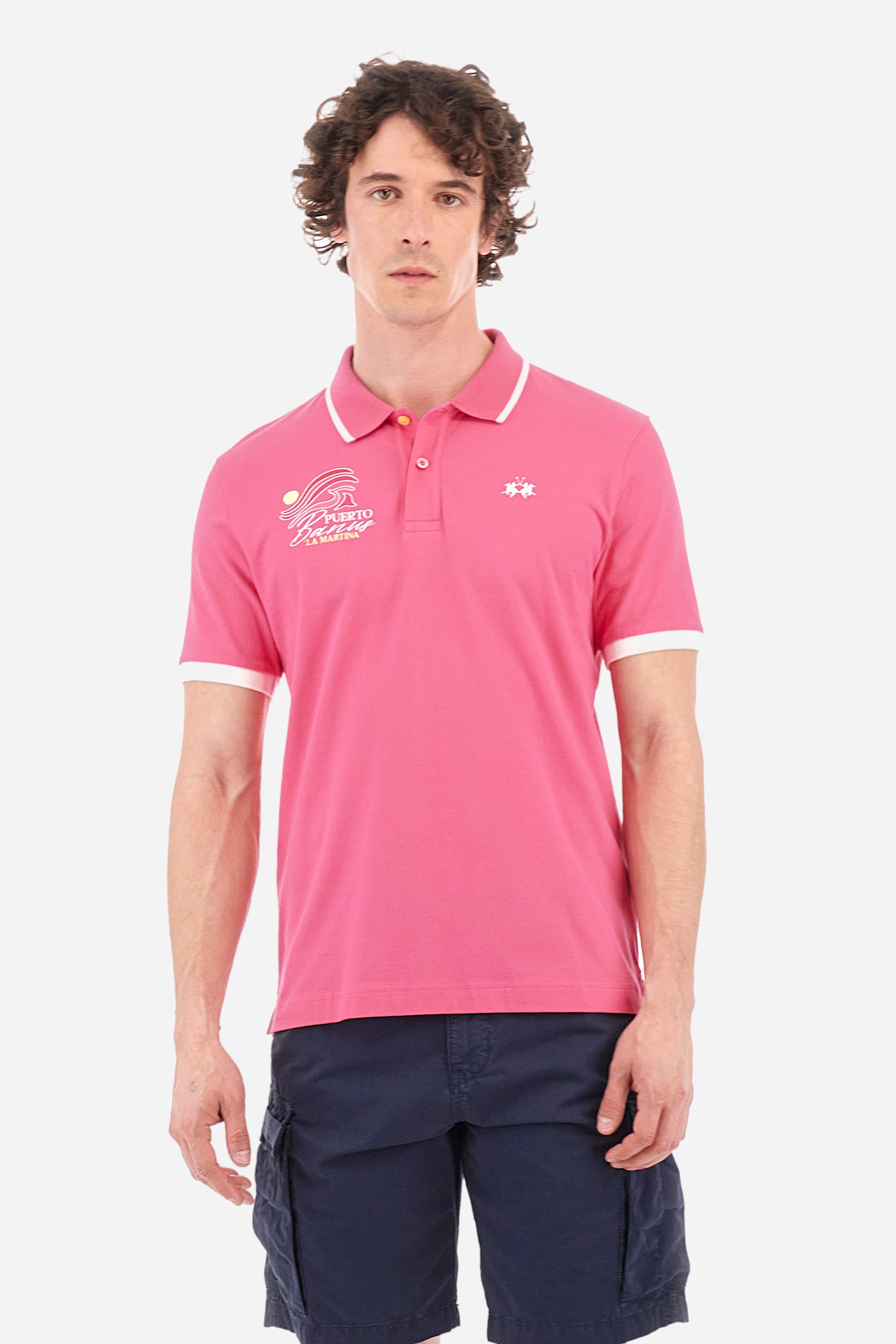 Men's short-sleeved single-colour polo shirt in elasticated cotton. Two-button fastening. With a profiled and ribbed collar and armholes. On the chest we find stylised waves with lettering. The back of the collar features the "La Martina" lettering. The logo is embroidered on the front. The fit is regular. The model wears a size L. - Hot Pink