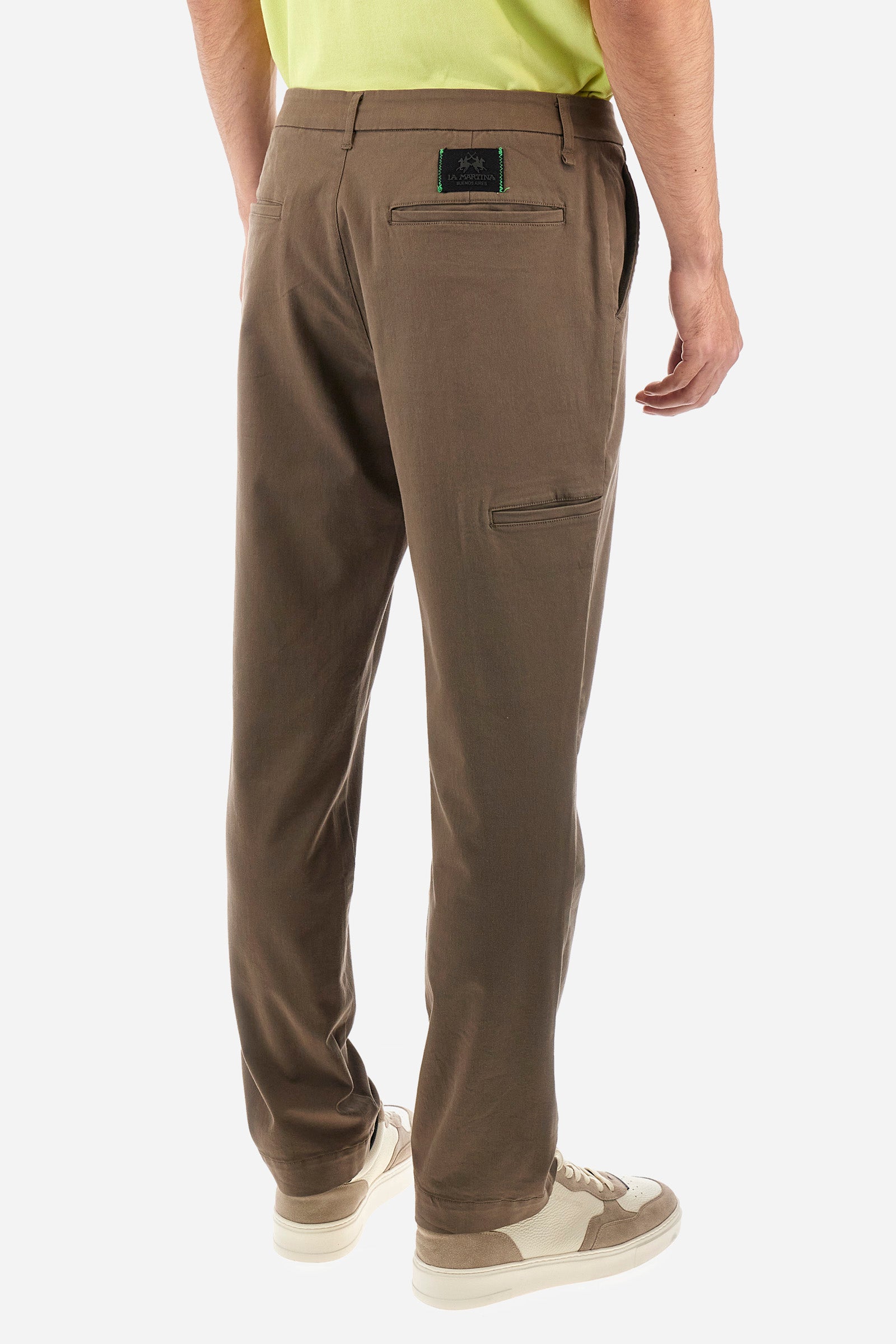 Men's single-colour chinos in stretch cotton. With belt loops, zip and button fastening. There are two functional front pockets, two rear pockets and two further pockets on the sides of the trousers. The logo is sewn on the back. The fit is regular. The model wears a size 33. - Bungee Cord