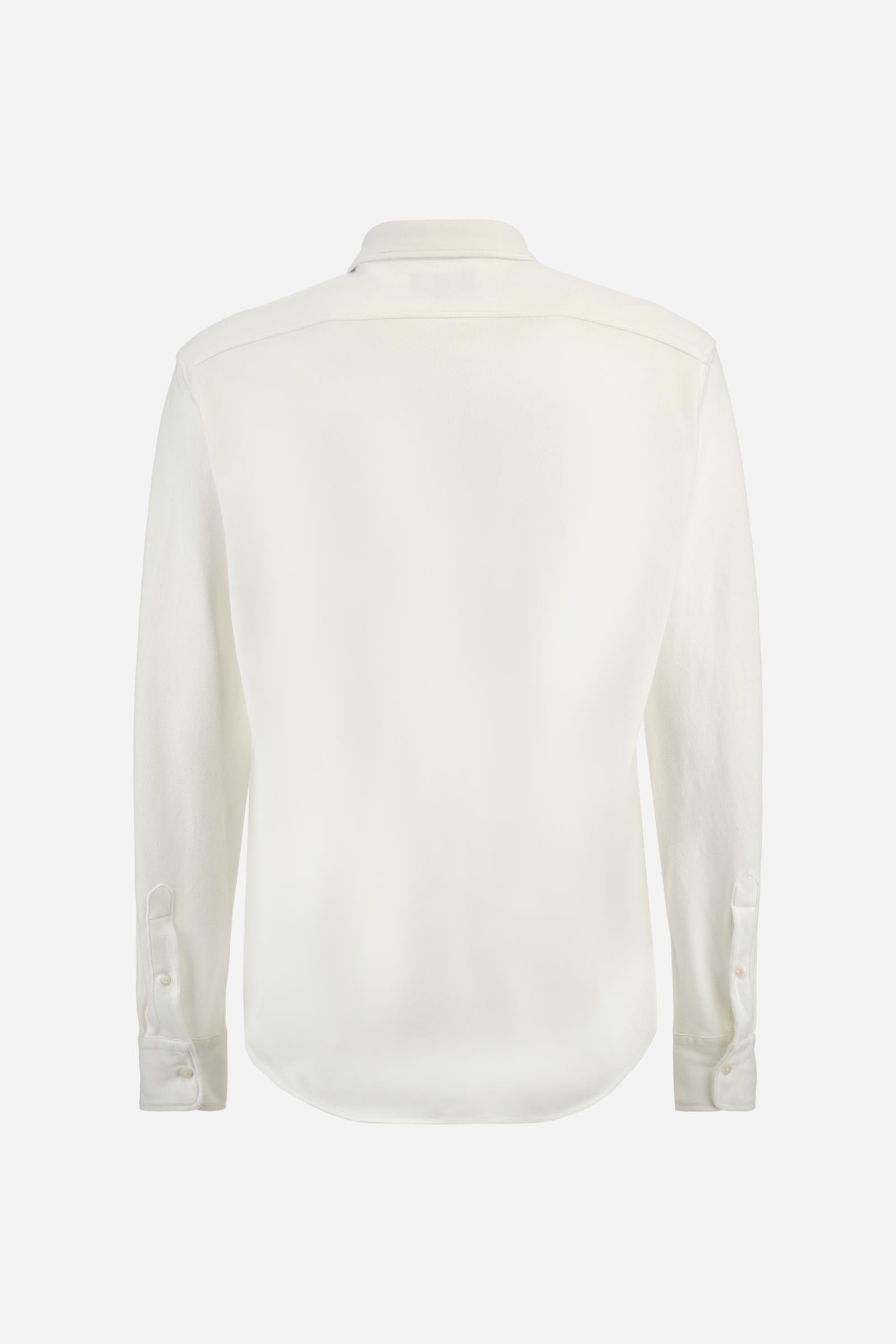 Men's plain long-sleeved shirt made from cotton piqué. It features an elegant spread collar and a seamless front opening, with no visible stitching. A graphic is embroidered on the chest, over the heart, in contrasting thread. Regular fit. The model is wearing a size L. - Optic White