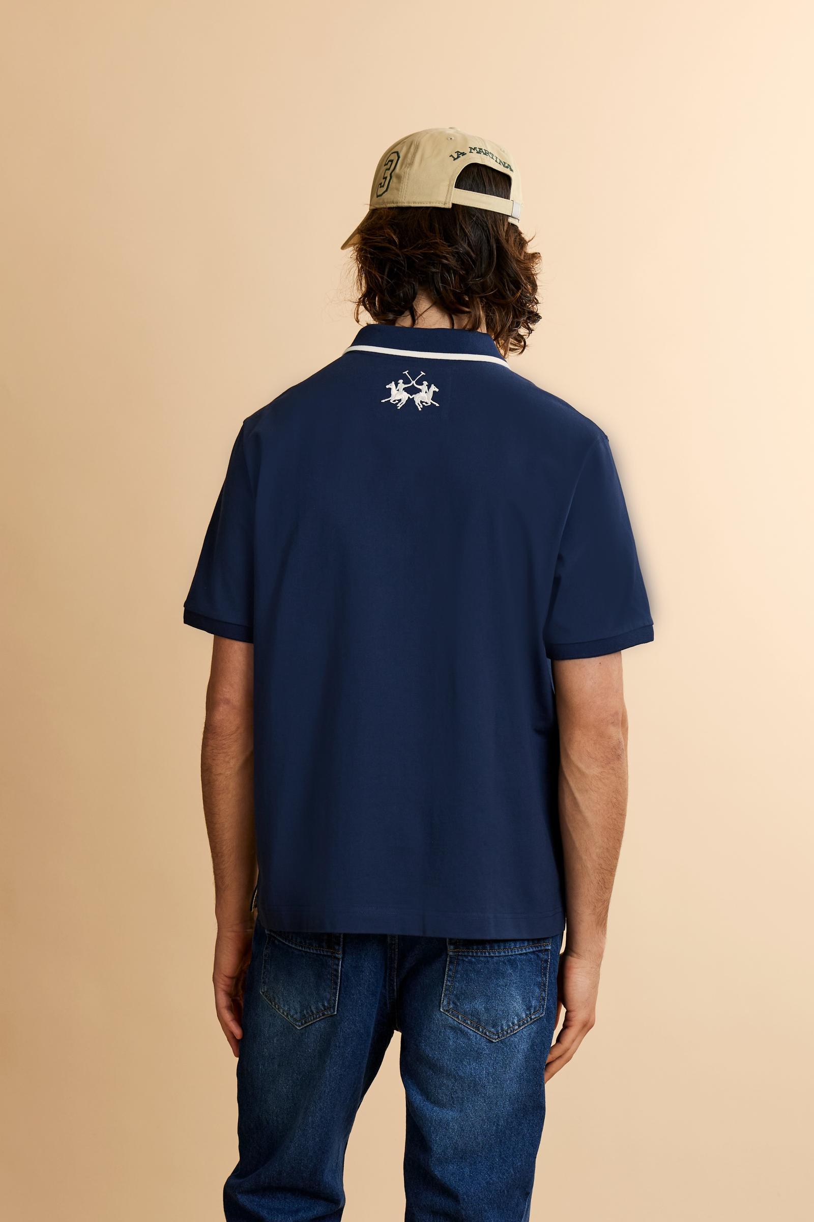 Men's short-sleeve polo shirt made from heavy-weight cotton jersey in solid color. The model features a front opening in contrasting jersey with vertically embroidered chain stitching. The collar and cuffs are ribbed with contrasting edge detail. The design is enriched with an embroidered crest on the chest dedicated to Saint Tropez and the iconic two polo players logo embroidered on the back. The fit follows modern trends with a slightly oversized silhouette, dropped shoulders and a relaxed shape. The mode
