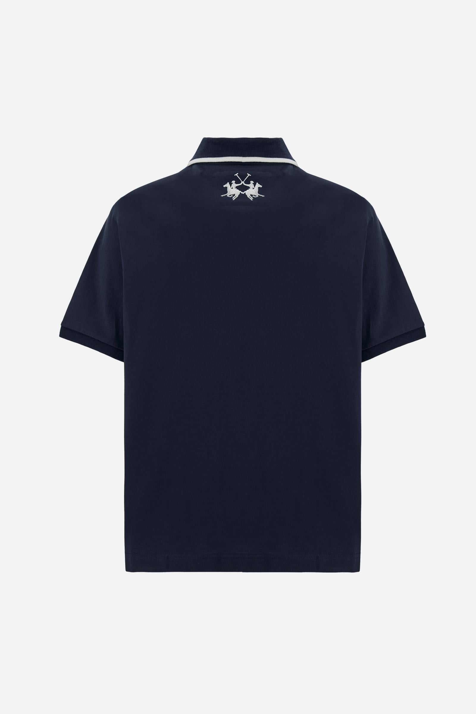 Men's short-sleeve polo shirt made from heavy-weight cotton jersey in solid color. The model features a front opening in contrasting jersey with vertically embroidered chain stitching. The collar and cuffs are ribbed with contrasting edge detail. The design is enriched with an embroidered crest on the chest dedicated to Saint Tropez and the iconic two polo players logo embroidered on the back. The fit follows modern trends with a slightly oversized silhouette, dropped shoulders and a relaxed shape. The mode