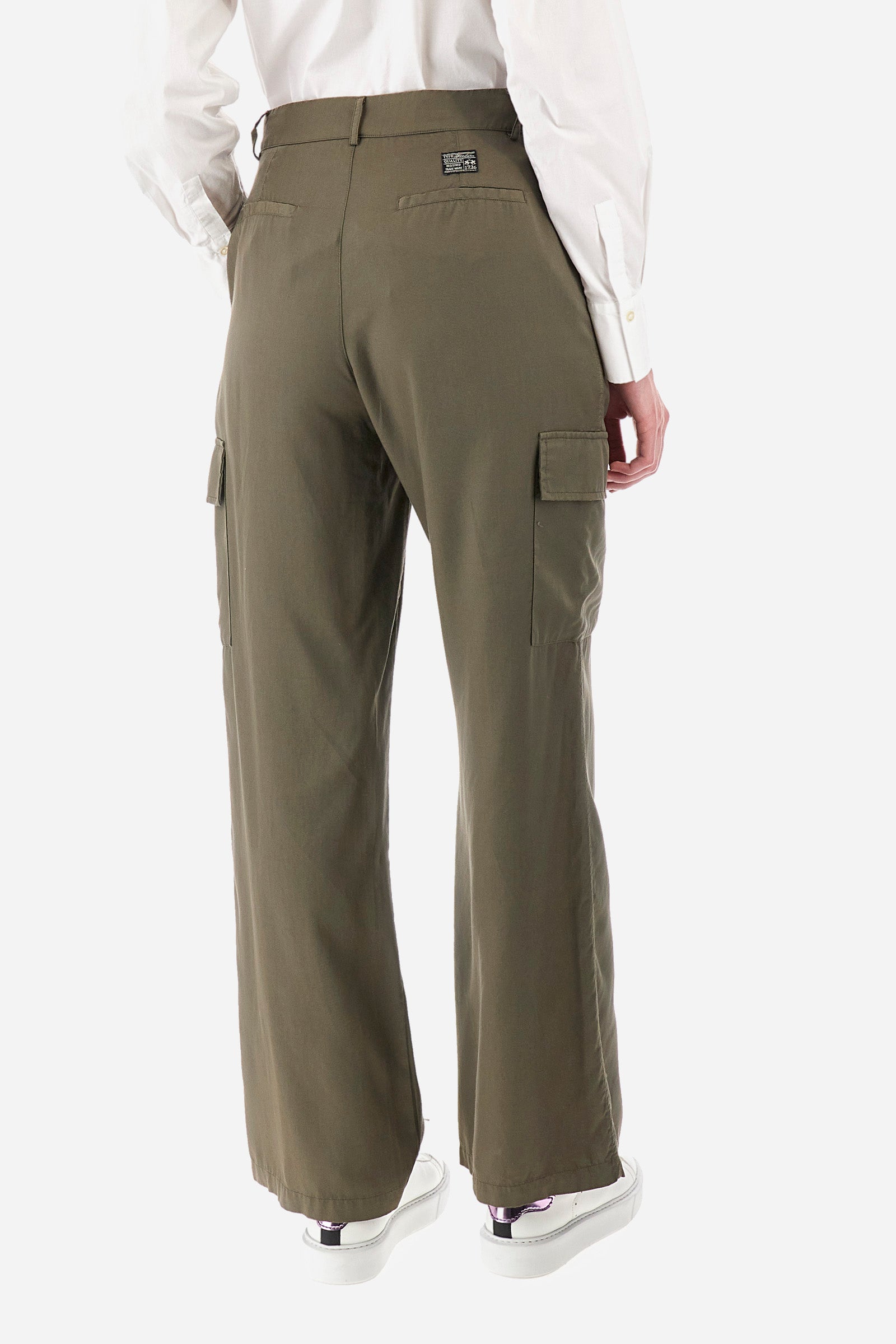 Single-colour women's cargo trousers, in an ecological fabric. With belt loops, zip and button fastening. There are two open front pockets, two cargo pockets and two further open pockets on the back. The logo is present on a patch sewn on the back and on a metal plate sewn on the front. The fit is regular. The model wears a size 40. - Military Olive