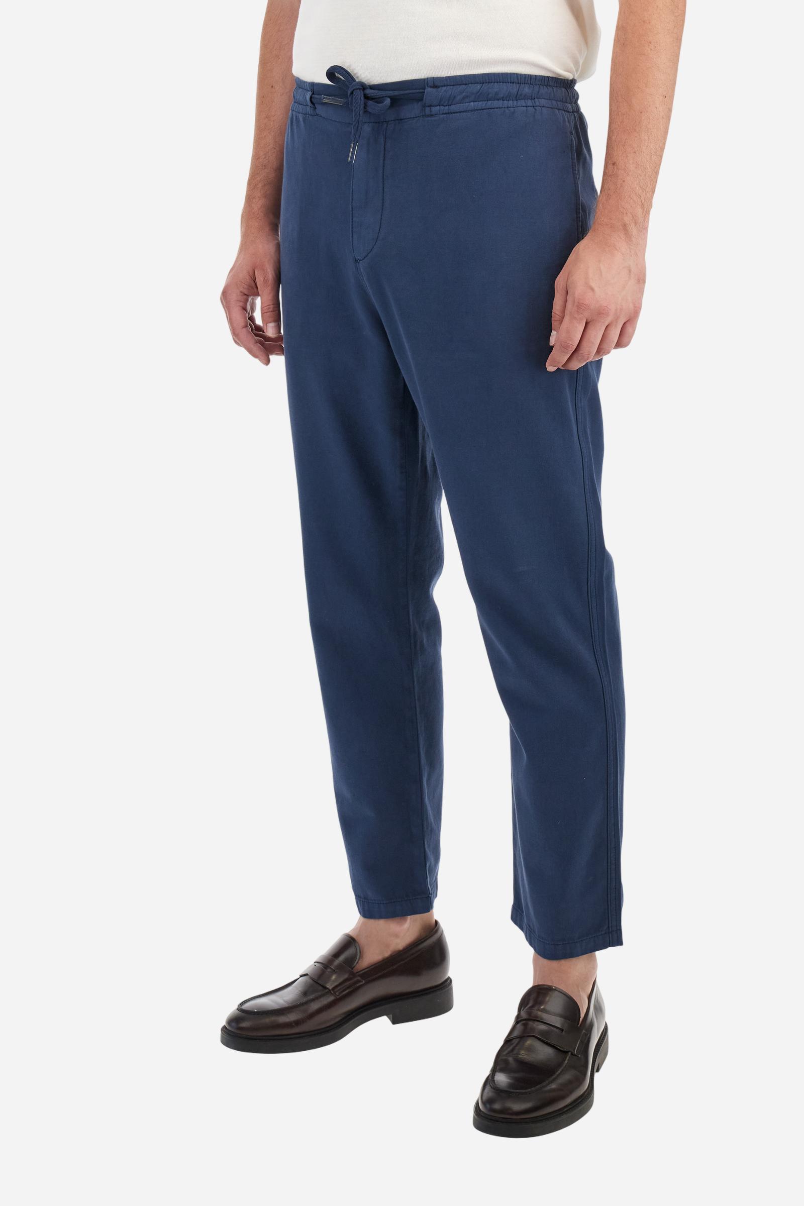 Men's plain straight-cut trousers, made of linen and cotton canvas. Featuring a waist belt at the back and on the sides with elasticated external drawstring for adjustment. The front opening also has a faux horn button on the belt and a zip. Double welt pocket inserted into the sides. There are two additional welt pockets on the back. The logo is featured on the woven label sewn above the right back pocket. Regular fit. The model is wearing a size L. - Navy