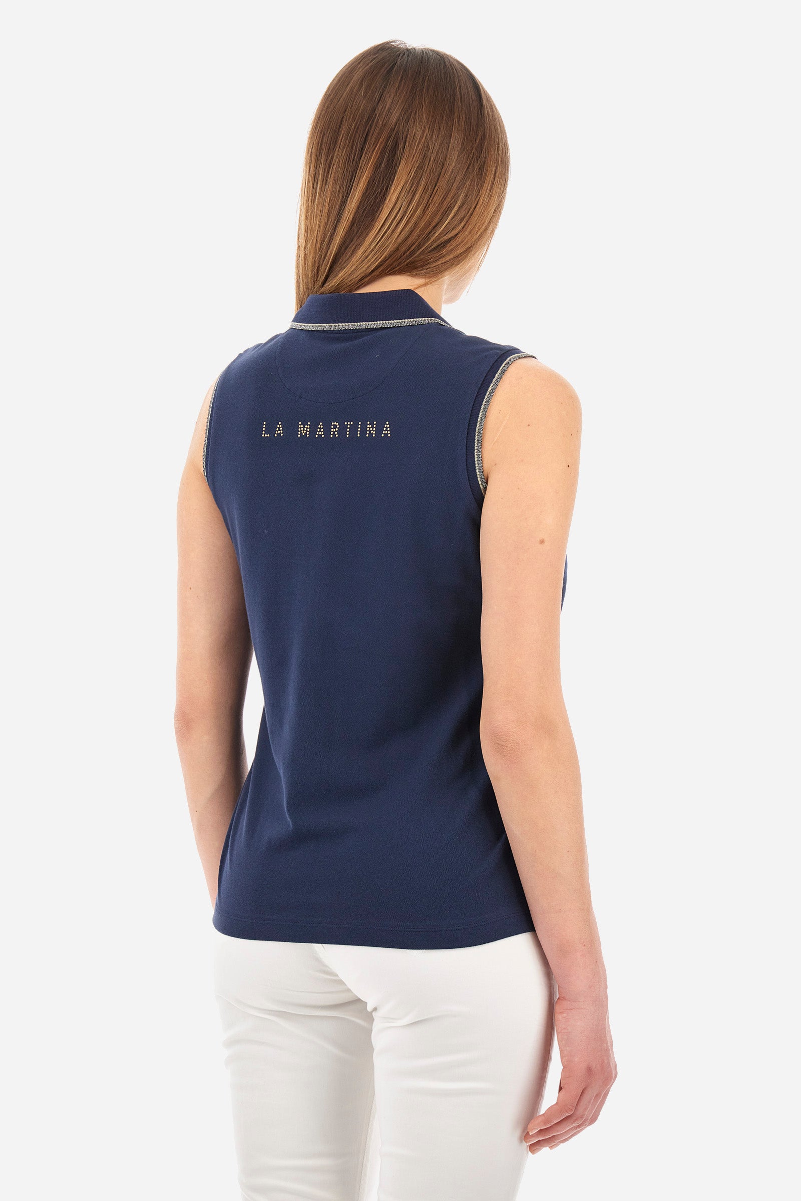 Women’s sleeveless polo shirt in solid color, made of stretch cotton. V-neck and 2 button closure. Collar and crew sleeves profiled and ribbed. Side slits. On the back there is the inscription "La Martina" composed of small rhinestones. The logo is present on the front. The fit is regular. The model wears a size 2 . - Navy