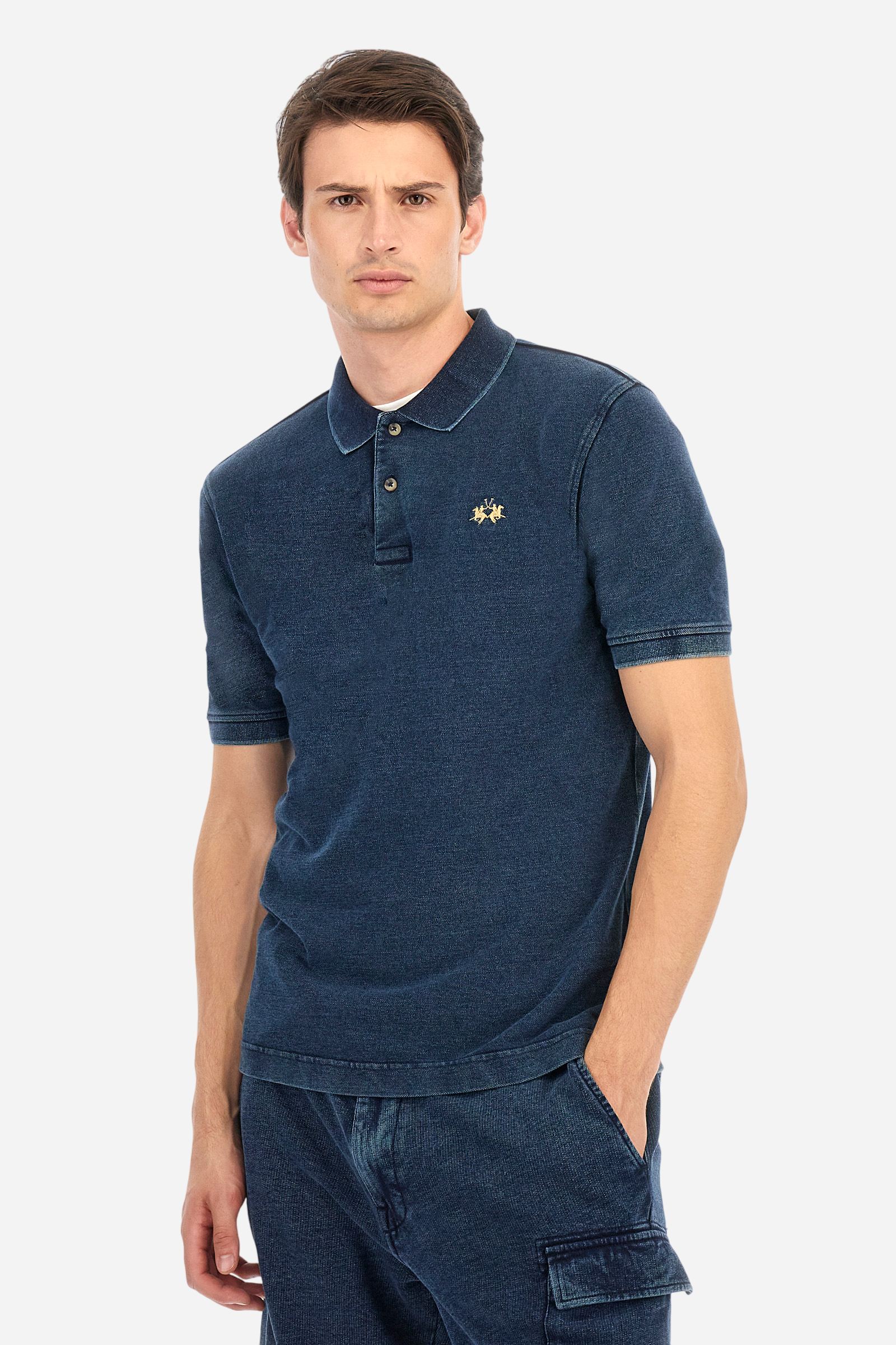 Men's short-sleeved polo shirt made of 100% cotton indigo pique. Fastens with two buttons. The collar and cuffs are folded and are made of ribbed fabric. Garment treated with enzyme washing, which gives the faded and lived-in look typical of denim. The contrasting embroidered logo is present on the left side of the chest. Regular fit. The model is wearing a size L. - Dark Indigo Denim
