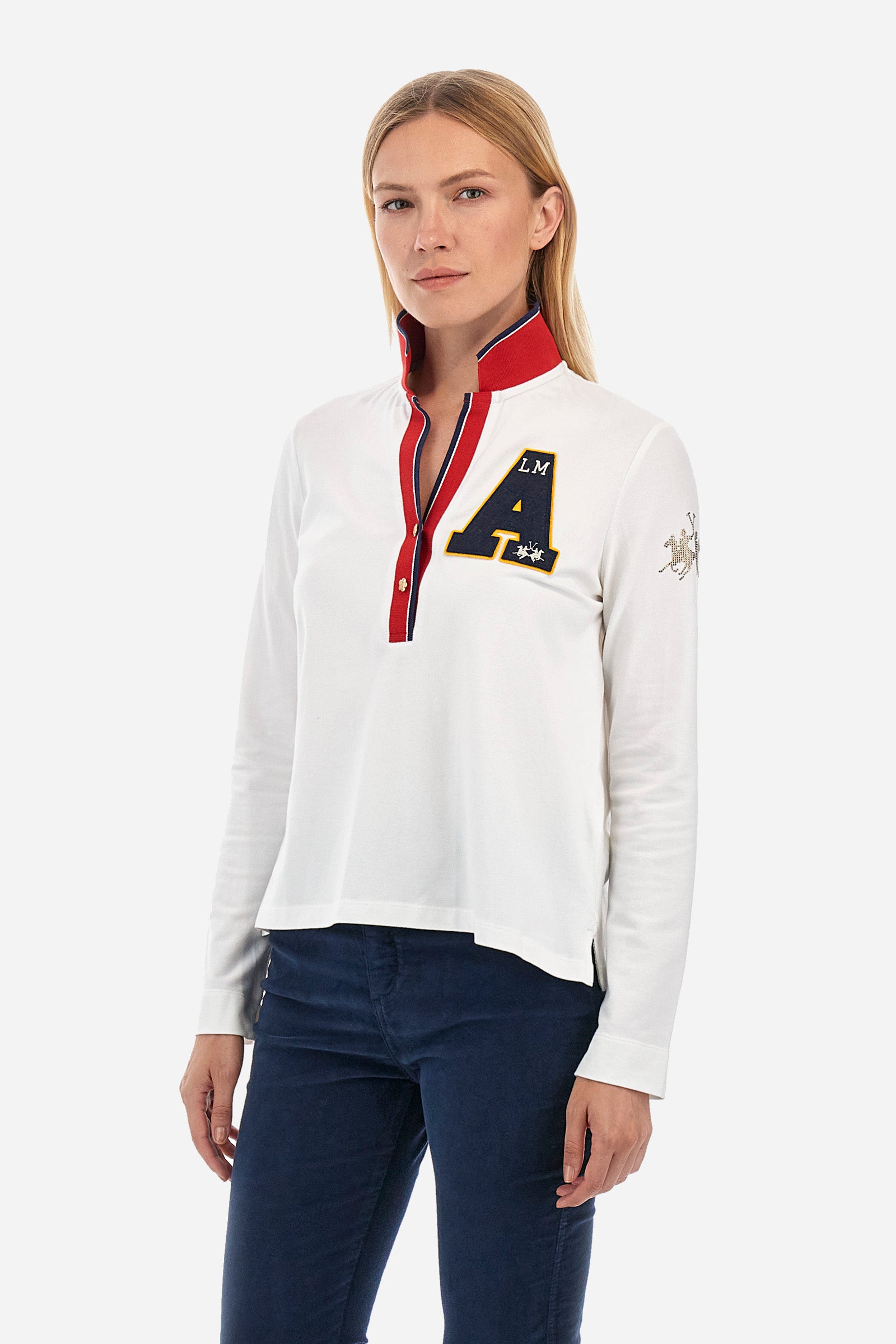 Women's long-sleeved polo shirt in stretch cotton, with regular lines in the Polo Academy style. The collar is classic, with a V neckline and double jewel button. Available in solid colour with different fun prints in contrasting colours on the garment. Featuring a rhinestone logo on the sleeve. This garment is designed for the practical and sporty woman who seeks comfort and style without sacrificing quality. Suitable for any occasion. The model is 174 cm tall and wears a size 2. - Off White