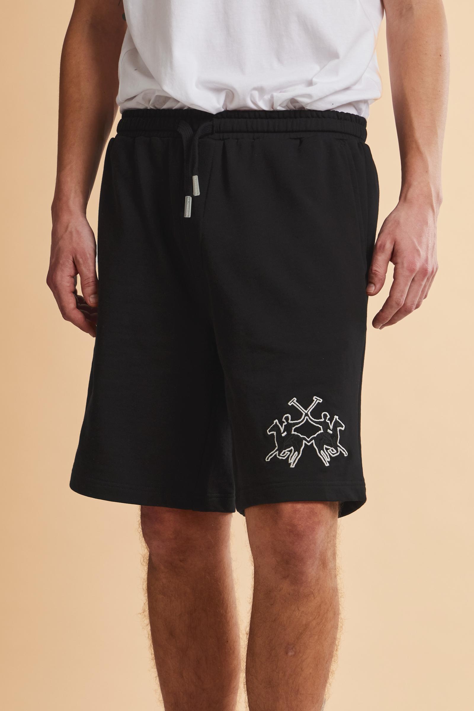 Men's bermuda shorts made from soft 100% cotton diagonal fleece. The regular relaxed cut reaches the knee and ensures maximum freedom of movement. The elastic waistband is completed by a flat tone-on-tone drawstring for adjustment. The design is finished with the brand's maxi logo embroidered in contrasting color with a 3D effect on the lower left leg. The model is wearing size L. - Black