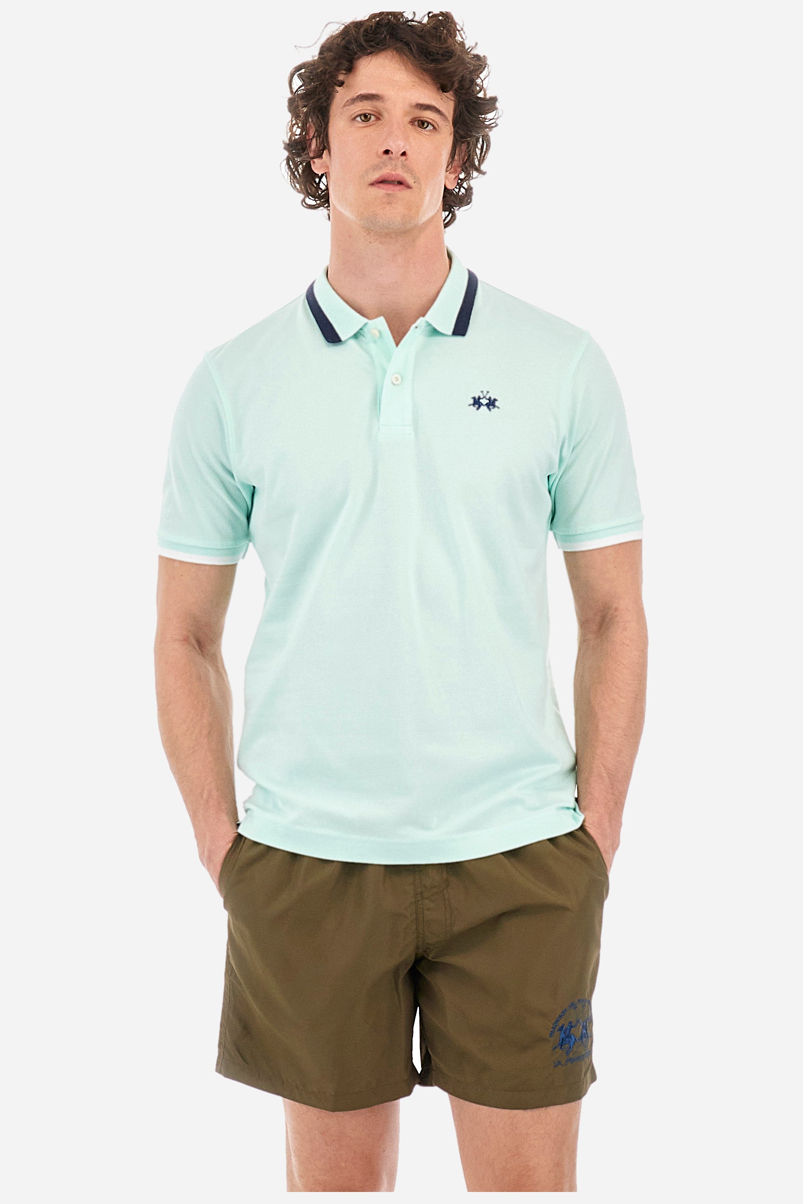 Men's single-colour short-sleeved polo in elasticated cotton. Two-button fastening. Ribbed collar and armholes with a stripe in different shades. The "La Martina" lettering can be found under the collar. Featuring a small logo embroidered on the chest. In a slim fit. The model wears a size L. - Honeydew